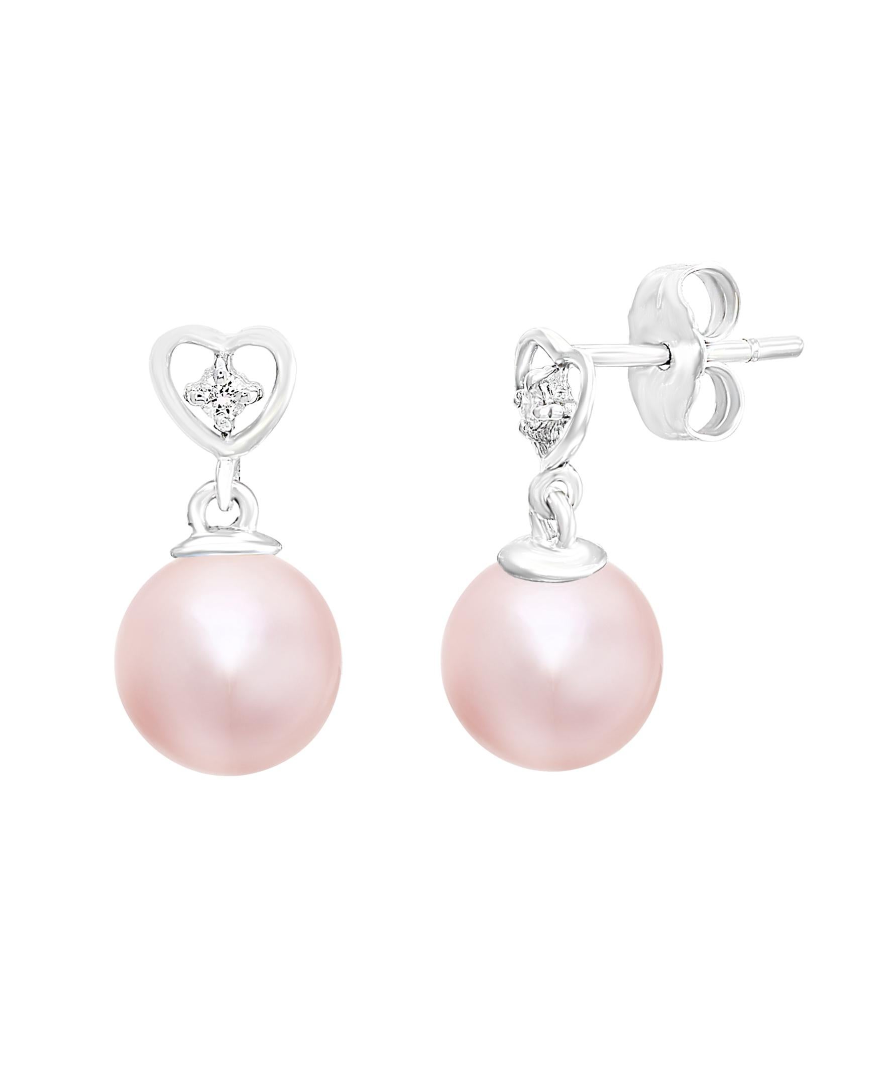 These elegant Diamond and Pearl earrings contain Chinese Freshwater natural-color pink round cultured pearls measuring 8-8.5mm dangling from white gold and diamond hearts with 0.04 carats of diamonds. Simple, yet elegant, these earrings are a great