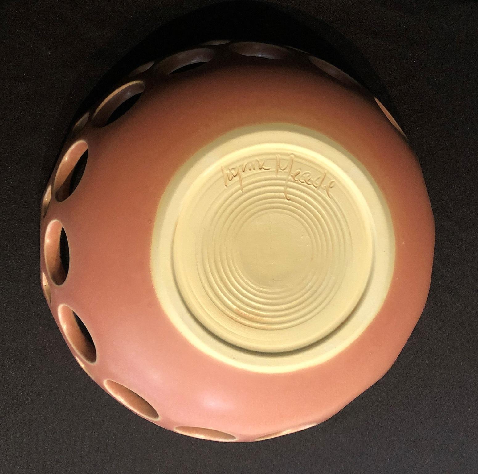 Inspired by Mid-Century Modern design, this bowl is wheel thrown and hand pierced stoneware. The satin glaze varies subtly from rhubabrb to pale pink to eggshell to white. Controlled, slow cooling in the kiln allows tiny crystaline structures to