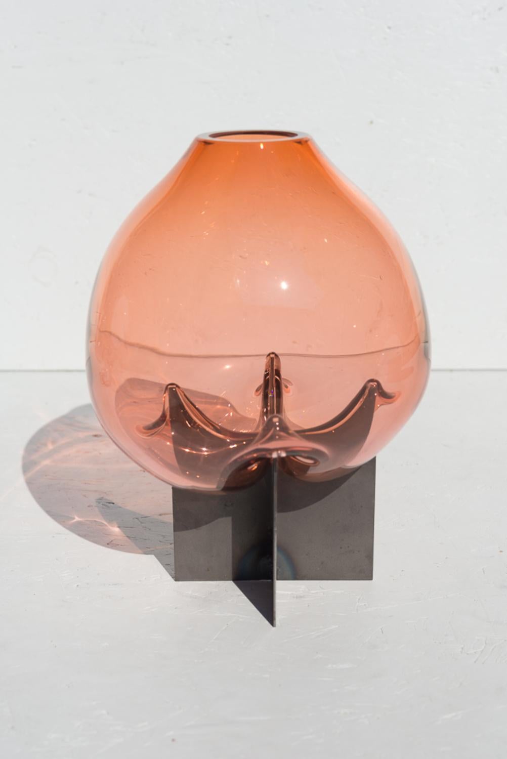 Pink pierced table vase by Studio Thier & van Daalen
Dimensions: W 35 x D 25 x H 25cm
Materials: steel, glass

The studio was keen to find a way to display the fluidity of glass. Therefore they sought the contrast between the industrial steel