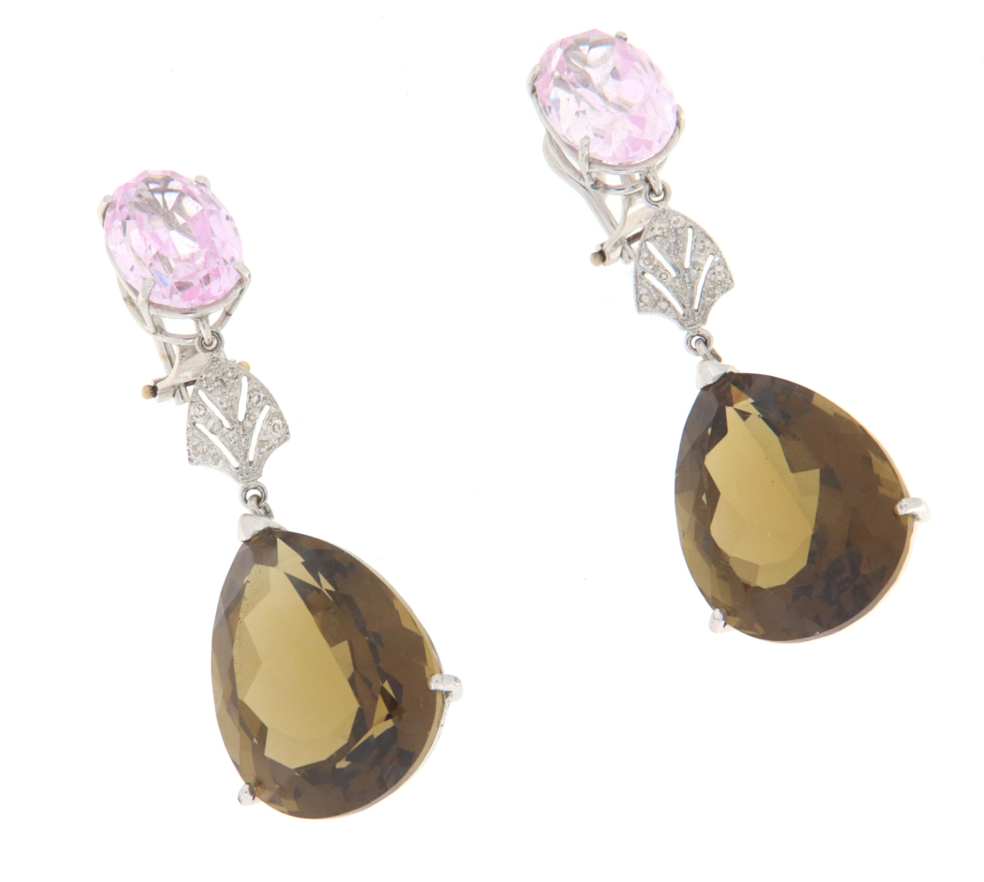 18 karat white gold earrings. Handmade by our craftsmen and assembled with pink quartz,drop citrine and diamonds.
In the highest part the two pink quartz hold two drops of yellow citrine accompanied in the center by a little diamonds.
Earring with a