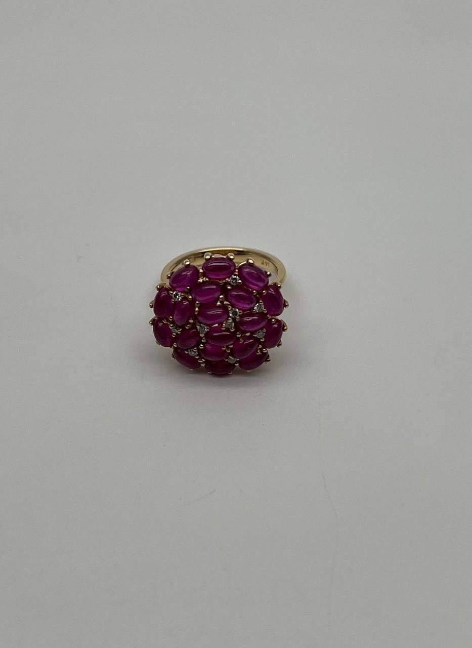 This exquisite piece features a cluster of vibrant pink red rubies set in a luxurious gold band. The stones are arranged in a captivating dome shape, creating a bold and eye-catching design. Each gemstone is meticulously set, allowing light to