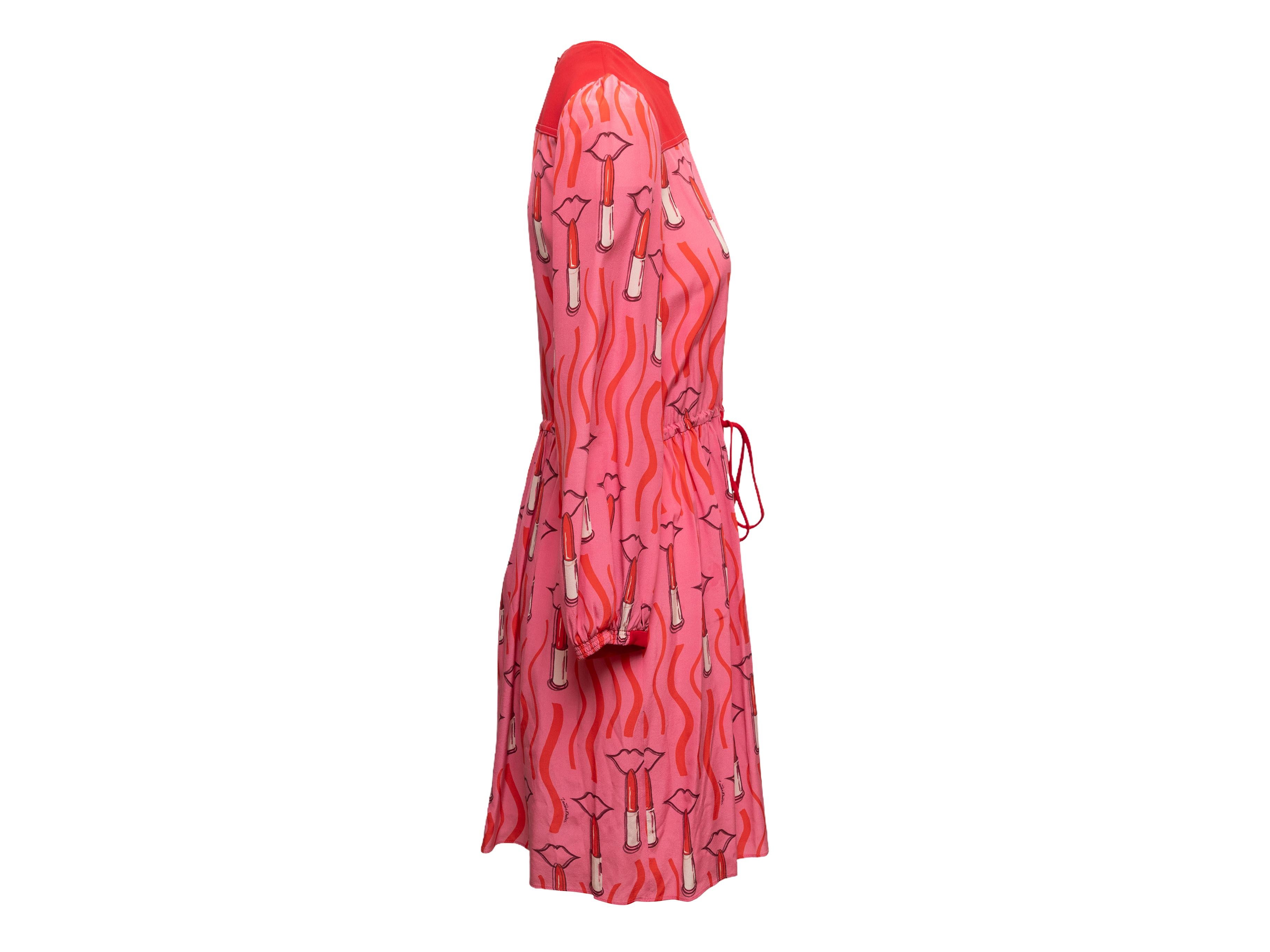 Robe à imprimé lipstrick rose et rouge de Valentino. Col ras du cou. Manches longues. Cordon de serrage à la taille. Fermeture à glissière au dos. Buste de 35