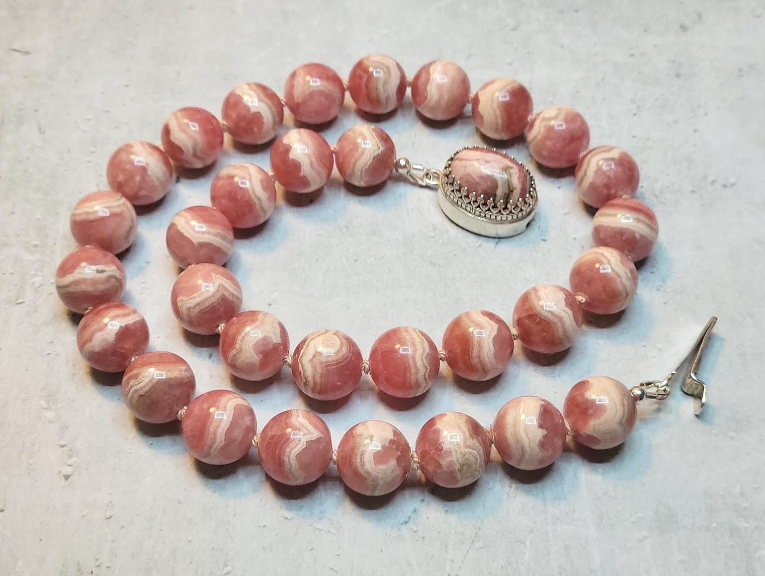 The length of the necklace is 18.5 inches (47 cm). The rare size of the smooth round beads is 13.5 mm.
Natural rose-red rhodochrosite. Authentic, natural color not treated in any way. Superior higher grade! The beautiful, interesting light pinky