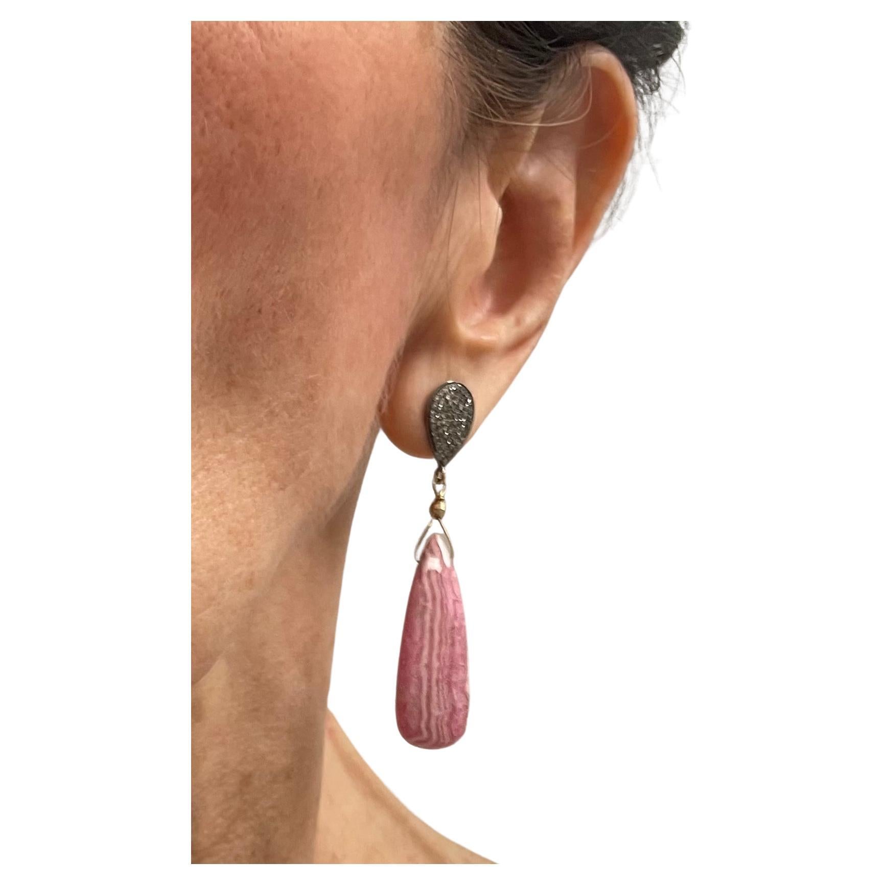 Description
Stunning Rhodochrosite, naturally embellished with its pink and white matrix and elegantly dangles from pear shape pave diamond posts.
Item #E2856

Materials and Weight
Rhodochrosite 30cts
Pave diamonds 1ct
14k yellow gold 3mm faceted