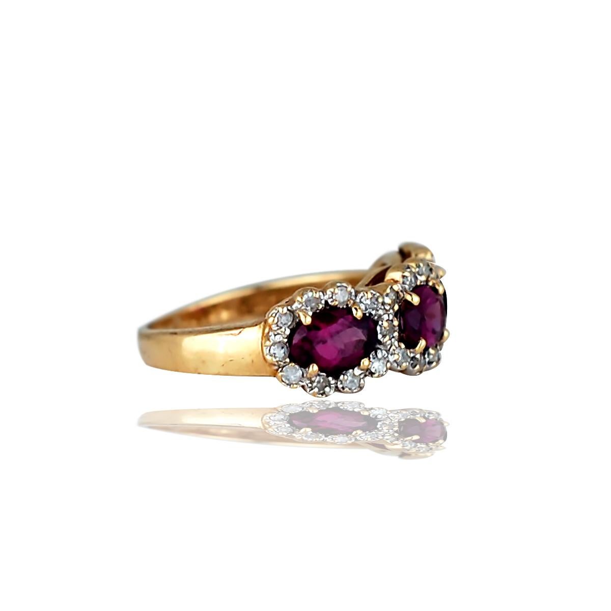 Lovely, 14 karat yellow gold ring features 3 oval cut prong set with pink Rhodolite stones horizontally and surrounded by round brilliant prong set diamond halos. 3 pink Rhodolite stones measure 5.9 mm x 3.95 mm x 2.85 mm and weigh approximately