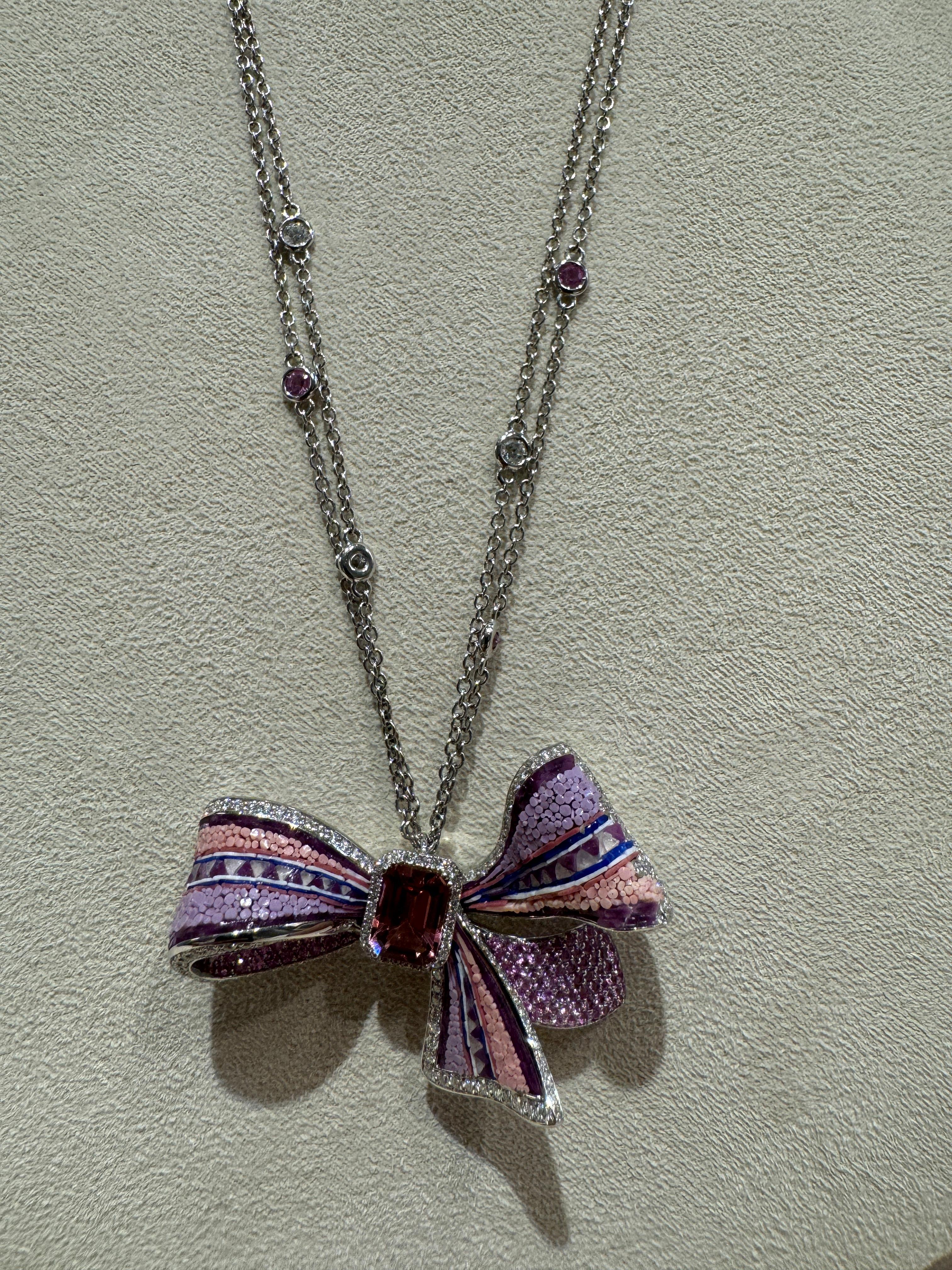 

Un nastro rosa in cui le tessere di micromosaico sono utilizzate come un filo speciale per creare questo spettacolare effetto tridimensionale. 
La tormalina centrale conferisce ulteriore lucentezza.



Diamanti Whiting 1,47ct
Zaffiri rosa 1,76