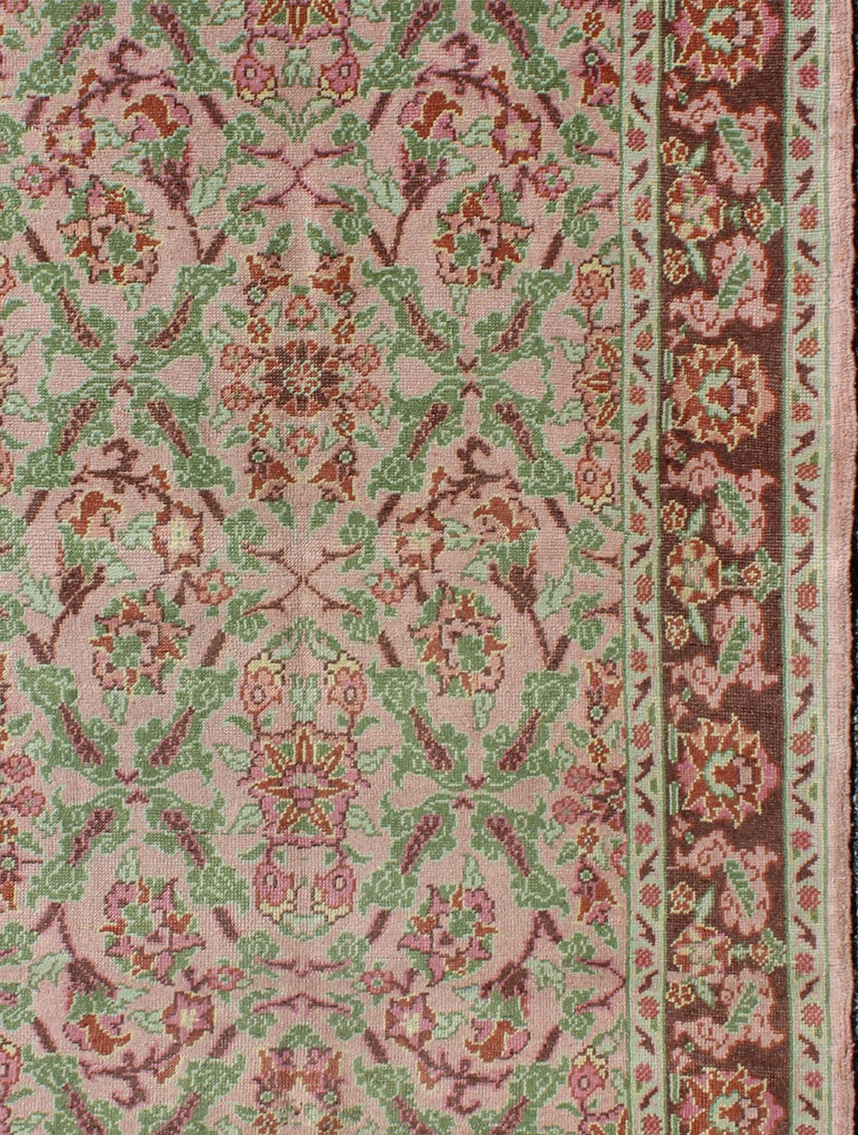 Measures: 4'1 x 6'7

Set on a light pink field with an all-over pattern, this beautiful midcentury Turkish Oushak rug (circa 1940) features cross-latch and lattice work with repeating blossom and flower motifs in their centers with light green