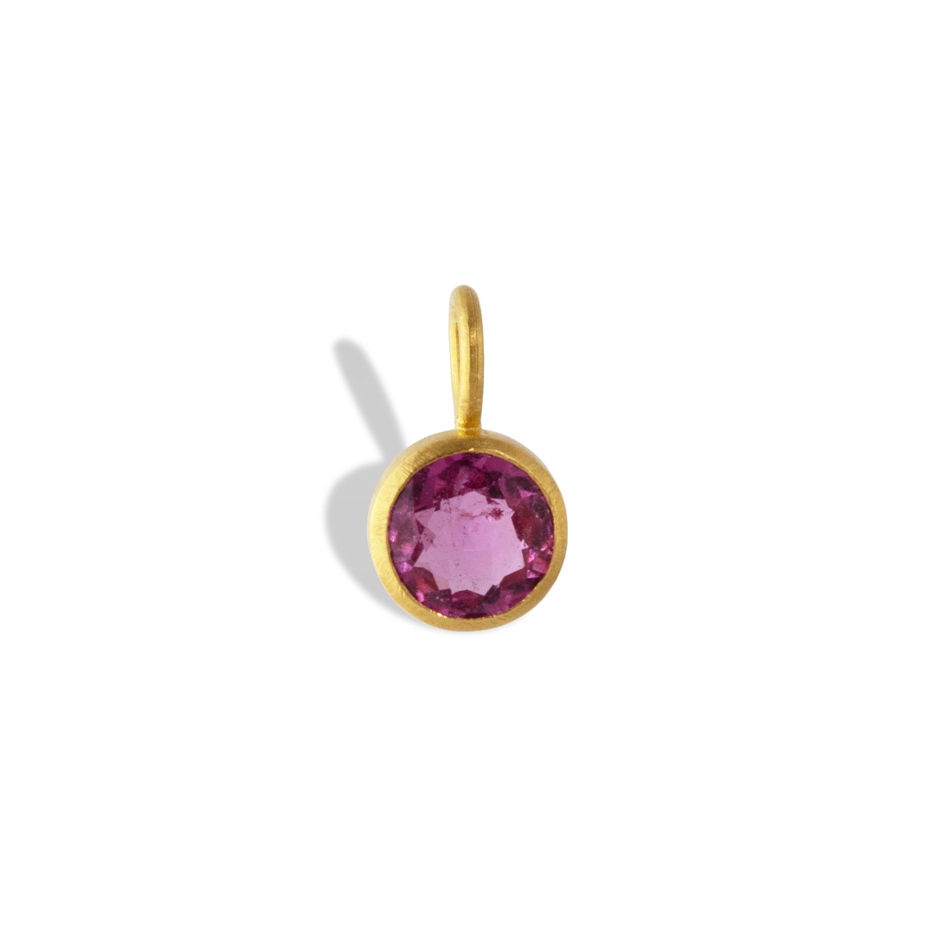 A deep pink rubellite tourmaline is set in 22k yellow gold.  This delicate pendant is 12.44mm long x 7mm wide and 5mm deep.

 Pink tourmaline represents a love of humanity and humanitarianism. It is worn to promote sympathy towards others.  It is