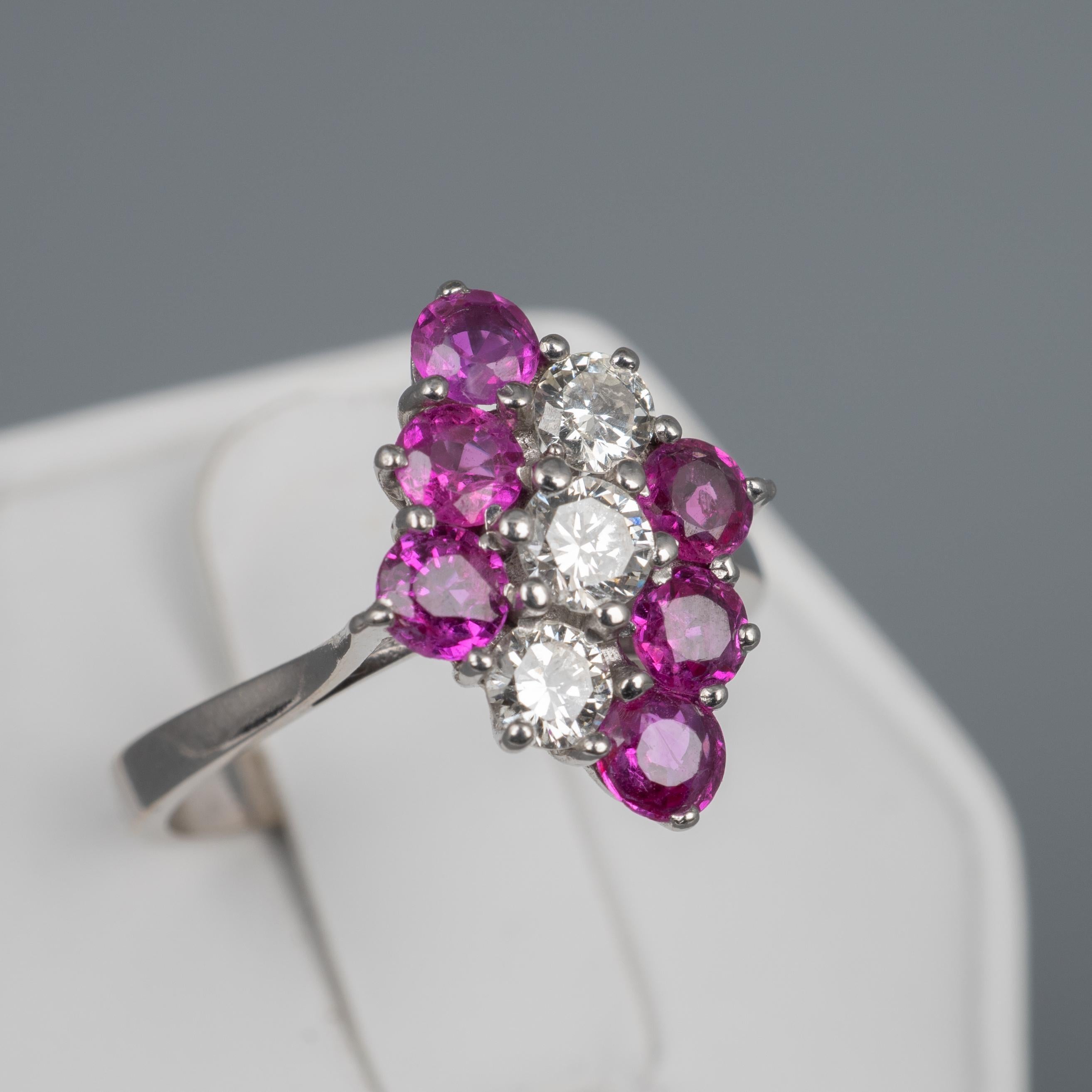 This gorgeous natural pink Ruby and Diamond ring is beautifully crafted in 18k white gold and features 1.3 carats of sparkling gemstones neatly arranged into a diamond shape cluster.

The setting features a row of three round cut diamonds totalling