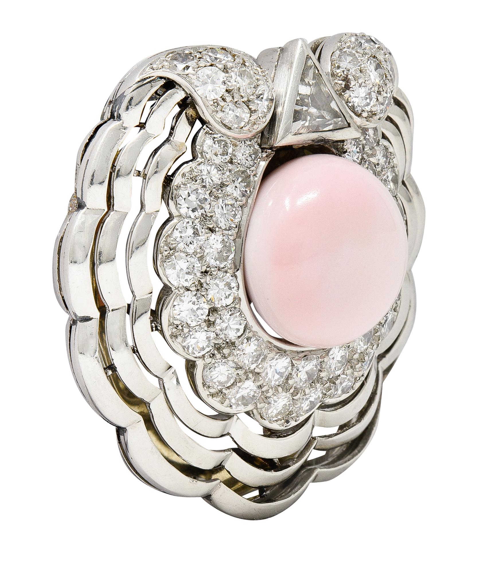 Centering a near-round conch pearl measuring 12.5 x 12.2 mm - opaque light pink in color. Natural saltwater in origin - with a fanning pierced shell motif surround. Featuring a surround of transitional and old European cut diamonds. With an