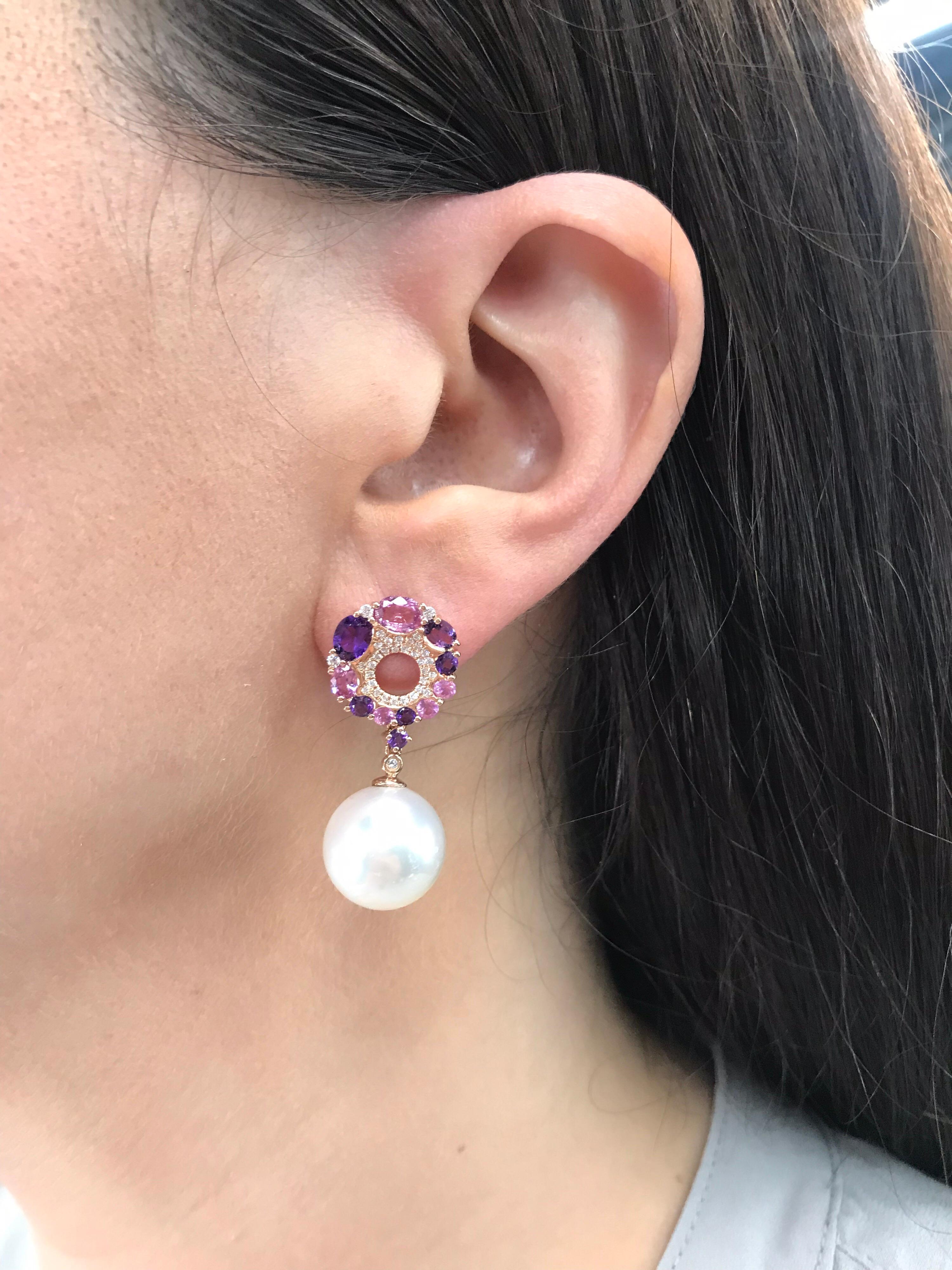 18K White gold drop earrings featuring 10 Pink Sapphires, 1.76 carats, 12 purple Amethysts, 1.38 carats, 68 round brilliants, 0.26 carats with two Pink Freshwater Pearls measuring 13-14 mm.  