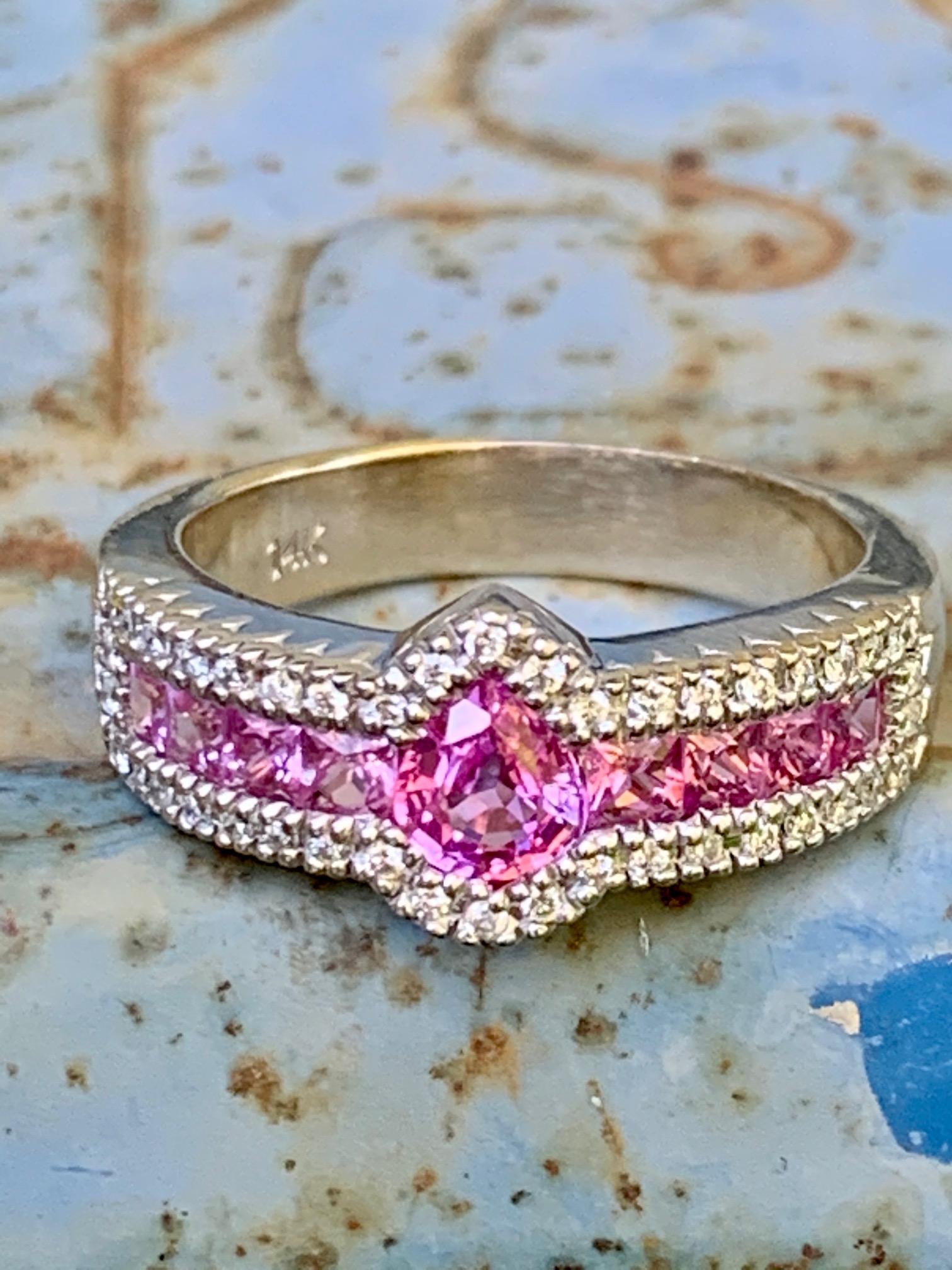 This beautiful ring features a 5.5 x 5.7mm faceted .50ct Pink Sapphire.  It is surrounded by 42 - 1.3mm Brilliant cut Diamonds with approximately .45ctw.  VS-G/H

Weight:  6.6 grams
Size:  8 1/4 - this ring is resizable but vendor does not offer