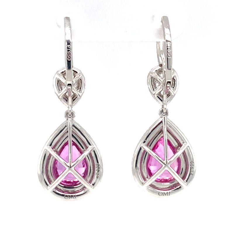 One pair of pink sapphire and diamond dangle platinum earrings by Omi featuring two 18K rose gold prong set, pear pink sapphires weighing approximately 3.31 ct. in total (1.65 ct. each) with 84 round cut pink sapphire accents totaling 0.85 ct. Also