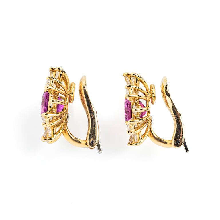 A lively array of pear and marquise-shaped diamonds surrounds intense pink sapphire centers in these decidedly modern floral form ear clips. Positioned at different angles, the diamonds create the illusion of movement. 

- Diameter approximately
