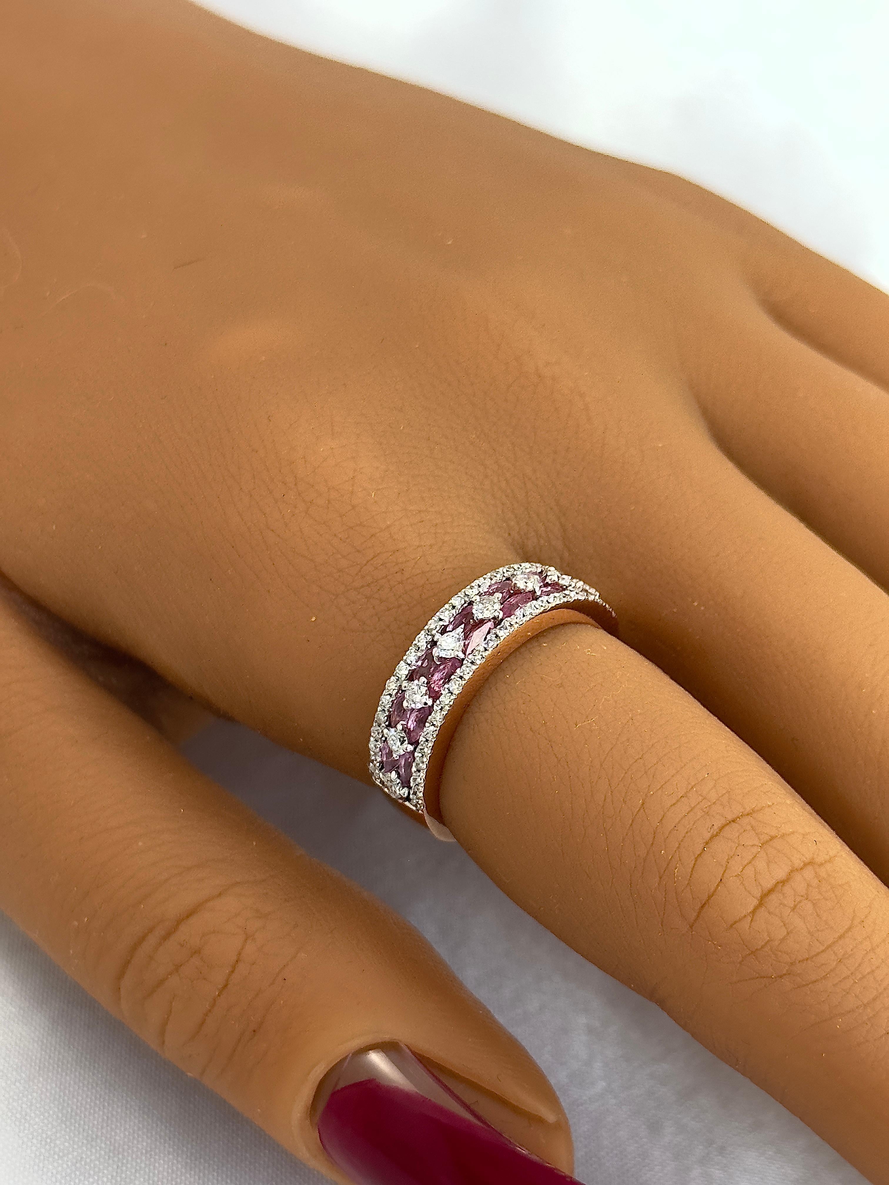 Pink sapphires and diamonds are back together! Marquise pink sapphires are set in two rows between white diamonds. There are eight round diamonds running through the center of the ring and smaller diamonds on the sides. The pink sapphire marquise