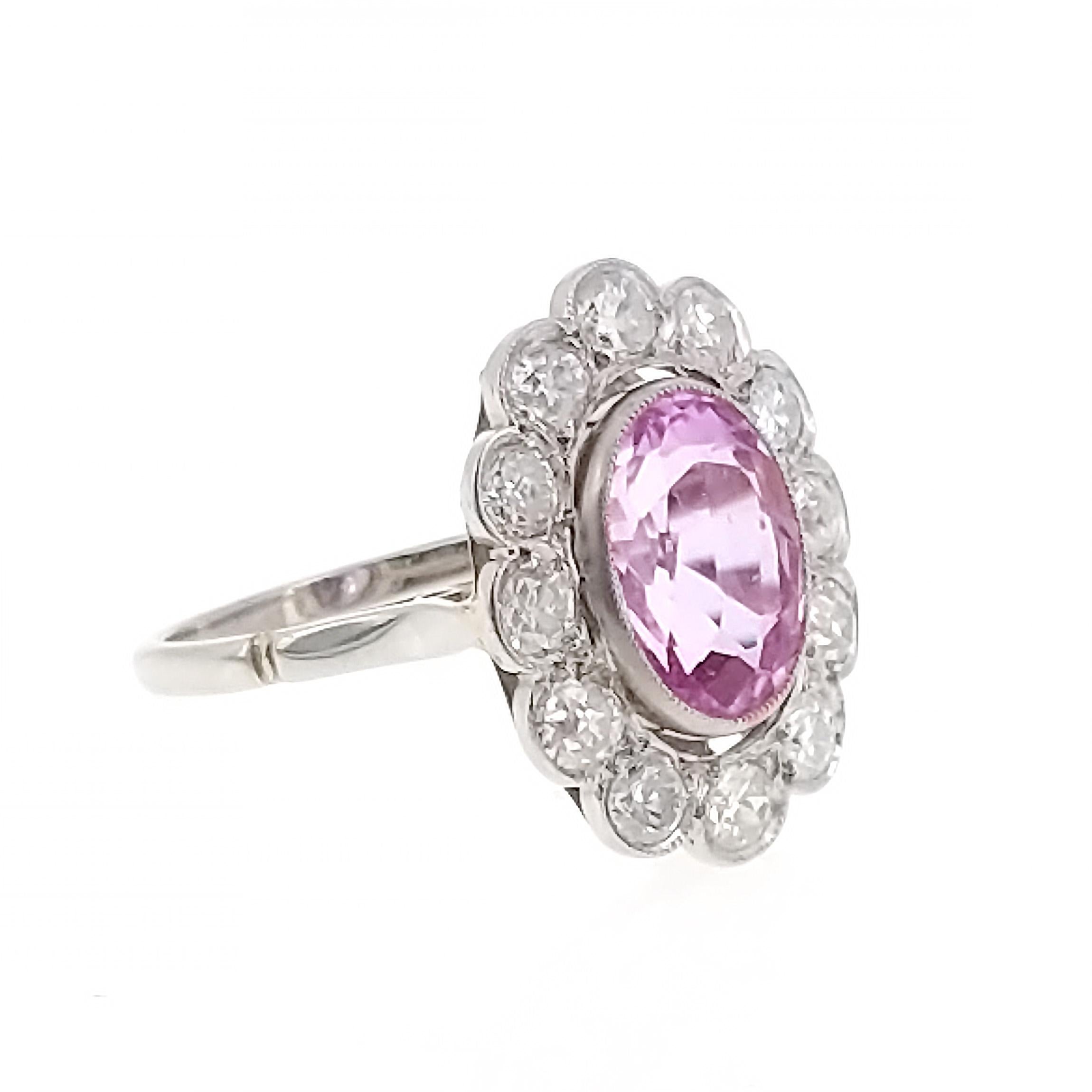 An elegant ring centering upon an oval-shaped pink sapphire of approximately 4.40 carats within a cluster of chunky circular- and old European-cut diamonds for circa 1.50 carats in total, mounted in platinum and 18k gold, with French assay marks,