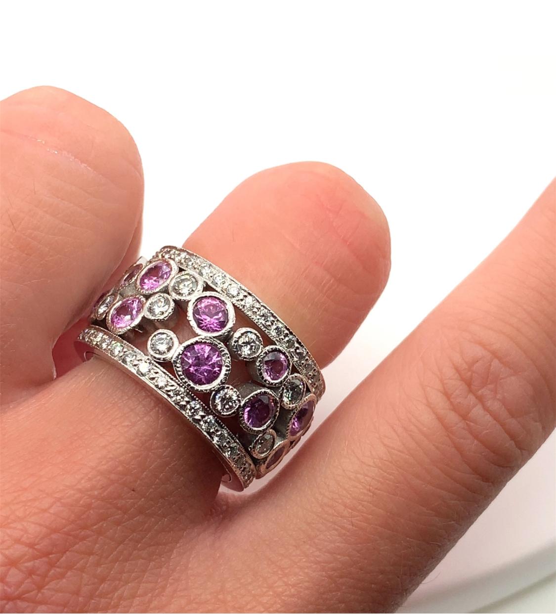 This exquisite engagement ring features a beautiful combination of natural sapphires and diamonds, set in 18ct white gold. The ring showcases a unique pave setting style, with a total carat weight of 4.10ct. The main stone is a round, vivid pink