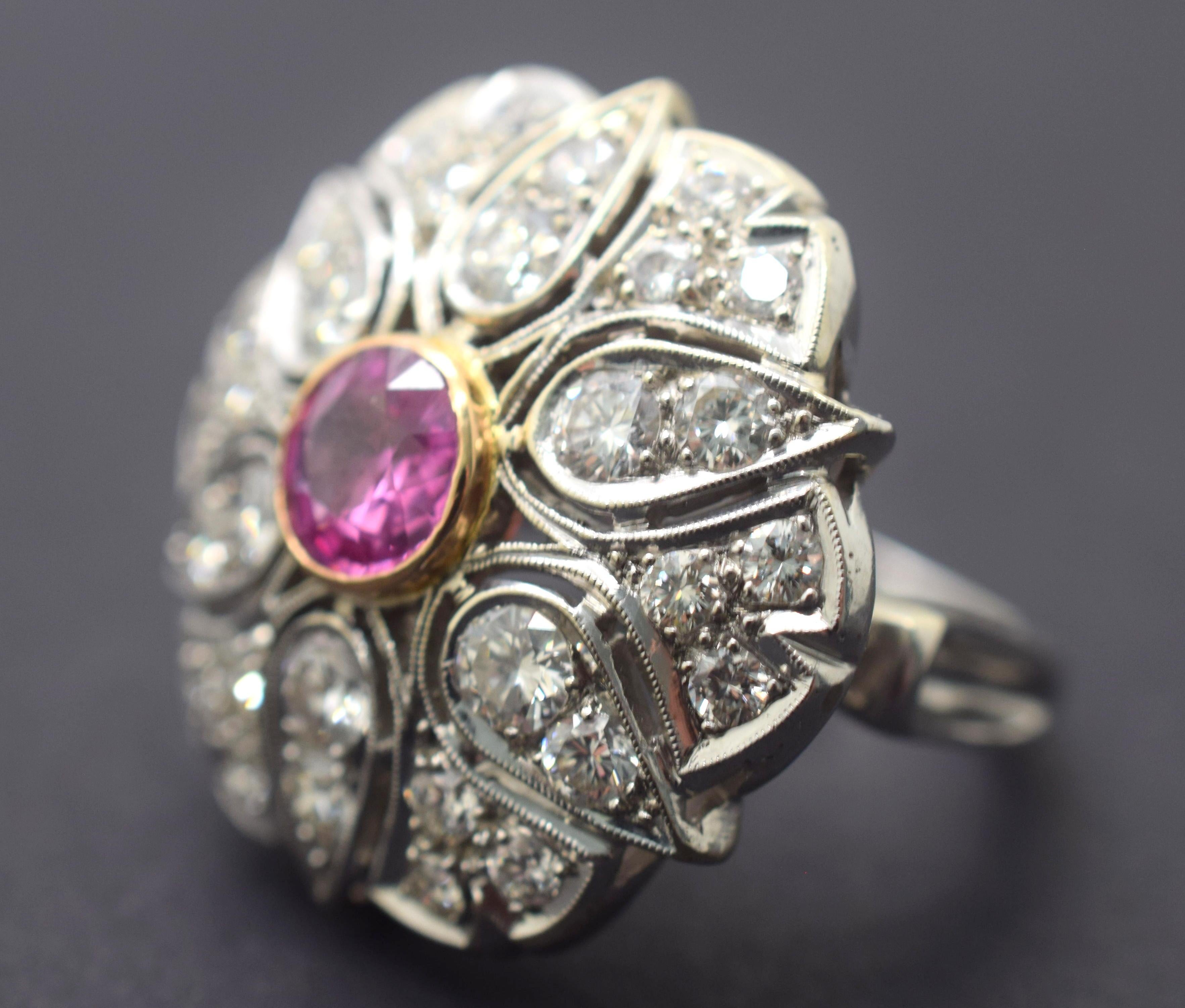 Gorgeous pink color in this natural no heat Pink Sapphire. Stone weighs 1.67 ct and is a brilliant round cut Sapphire.  Sapphire is bezel set and surrounded with Diamonds on the head of this ring. The ring shows a star pattern with thirty individual