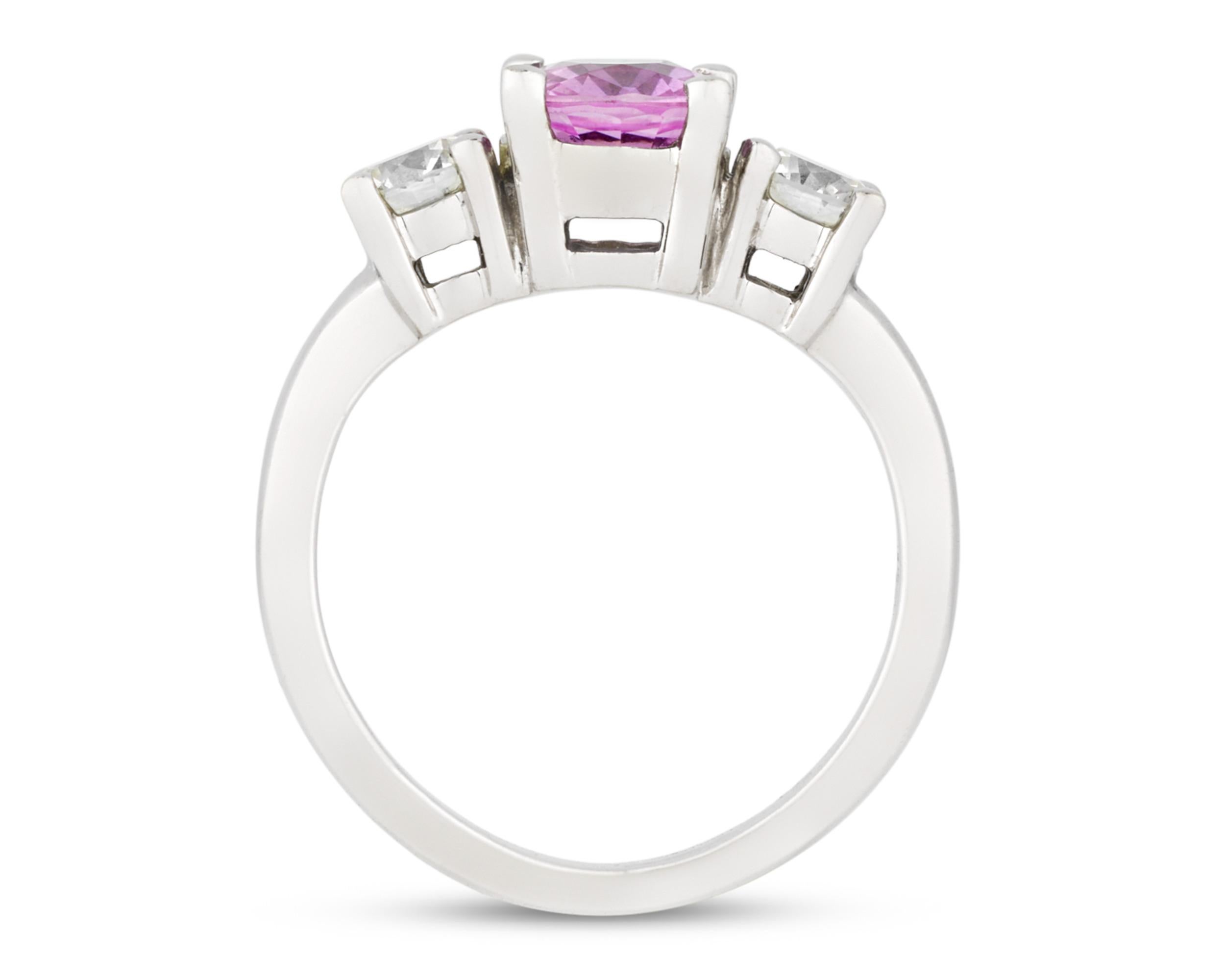 The graceful pink sapphire at the heart of this endearing ring weighs approximately 0.80 carat and is flanked by two sparkling white diamonds. Set in 14K white gold. 