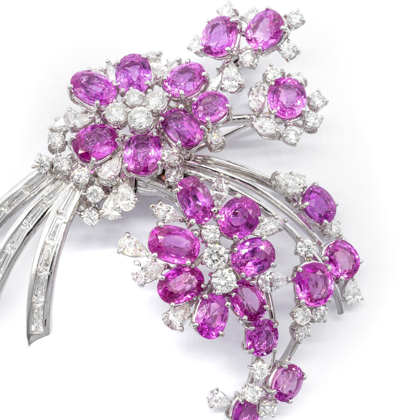 A vintage pink sapphire and diamond spray brooch, set with pink sapphires, forming a bouquet of flowers, set with baguette-cut and round brilliant-cut, marquise-cut and pear-cut diamonds, in 18ct white gold, circa 1955. Measures approximately 60 x