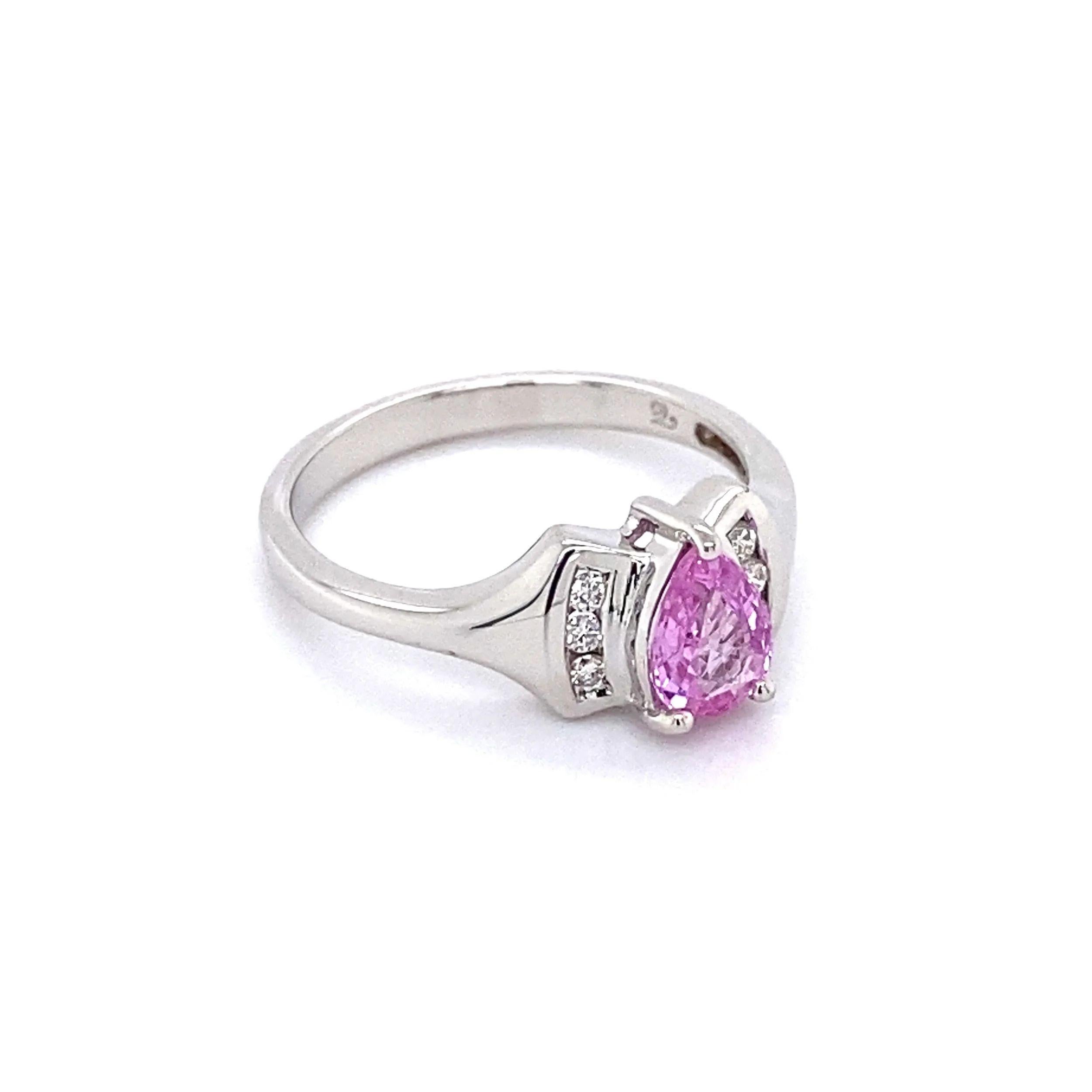 Simply Beautiful!  Pink Sapphire and Diamond Gold Band Cocktail Ring. Centering a securely nestled Hand set Pear shape Pink Sapphire, weighing approx. 0.50 Carat. Accented either side by Diamonds, approx. 0.06tcw. Hand crafted in 18K White Gold.