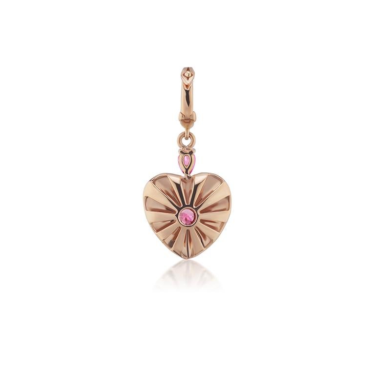 18k gold heart shaped pendant with a Pink Sapphire centre and top pear, rays of white enamel and gold. The diamond encrusted bezel opens to allow you to securely hook it to any chains.  

The Mila Heart was designed to celebrate the birth of my