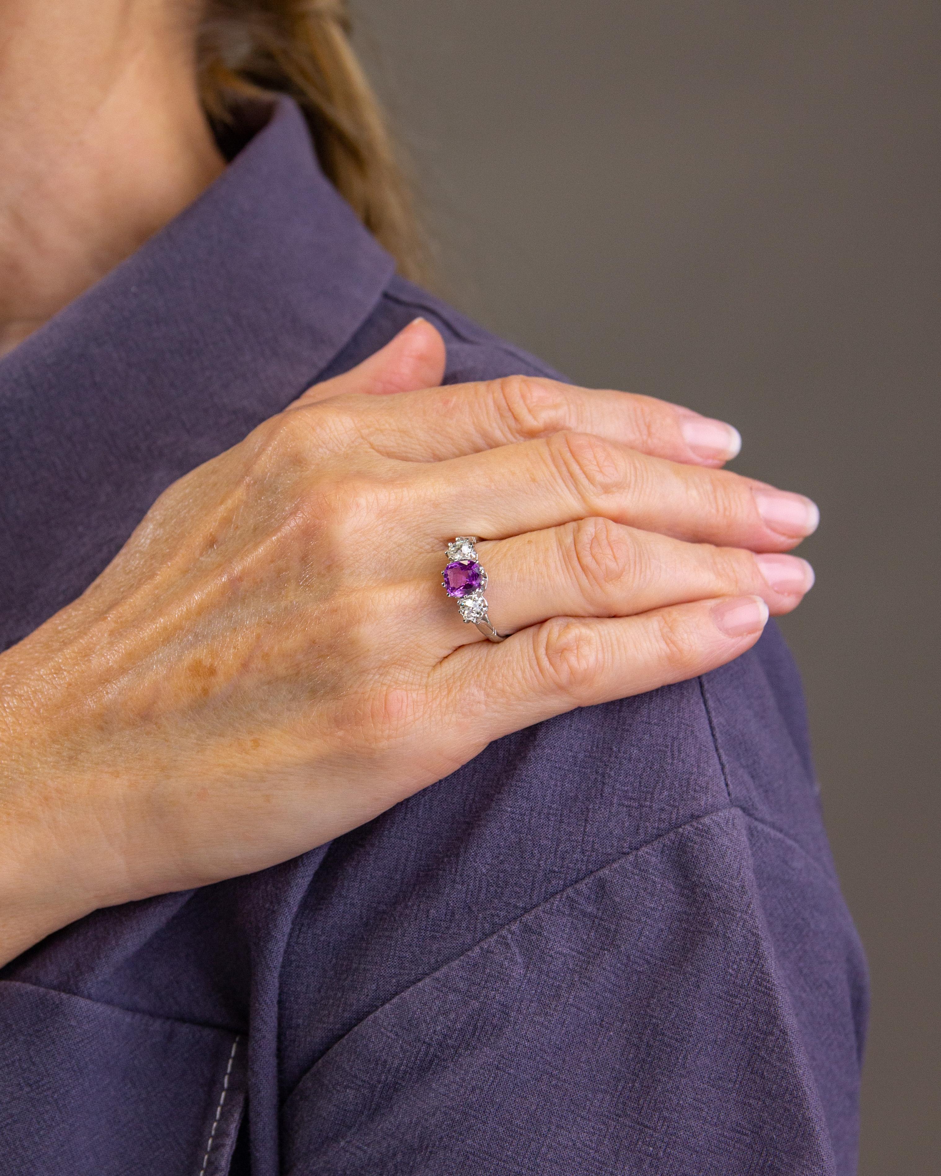 Crafted from platinum and set with a pink sapphire and two old cut diamonds, this ring really is a shining beauty. Whilst the ring is of no great age, it has been crafted in an antique style and utilised old European cut diamonds. The central square