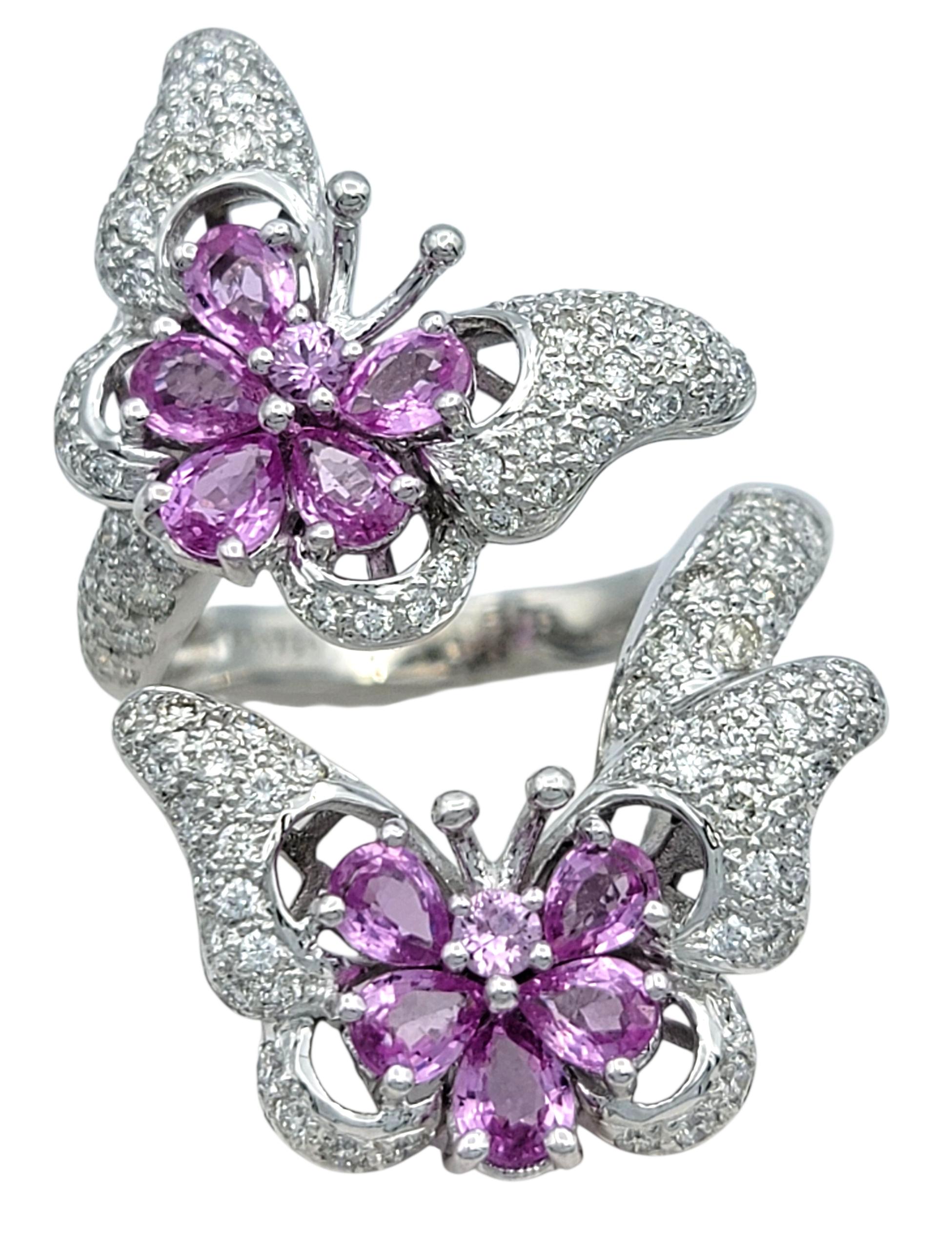 Ringgröße: 7

Dieser skurrile und bezaubernde Schmetterlingsring glänzt mit einer Explosion von rosa und weißem Glanz. Zwei Schmetterlinge im Flug, gefasst in 18 Karat Weißgold, sind aus rosa Saphiren im Birnen- und Rundschliff gefertigt und bilden