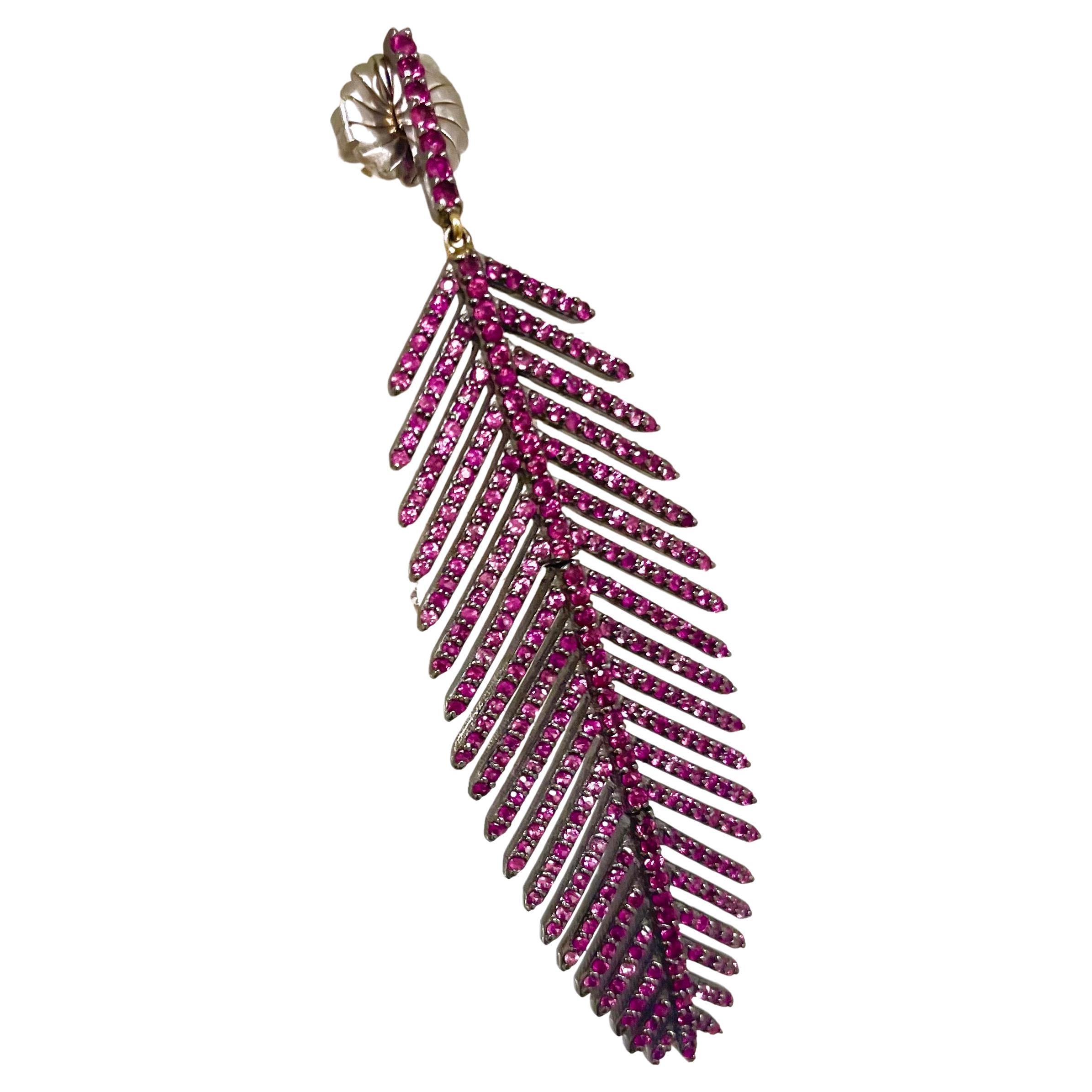 Description
Eye catching, exquisite, stunning pink sapphire enhanced by red rubies on the ear post and along the feather quill line. 
Item #E3297

Materials and Weight
Pink Sapphire and ruby, total 6.17cts
Rhodium sterling silver
14k yellow gold