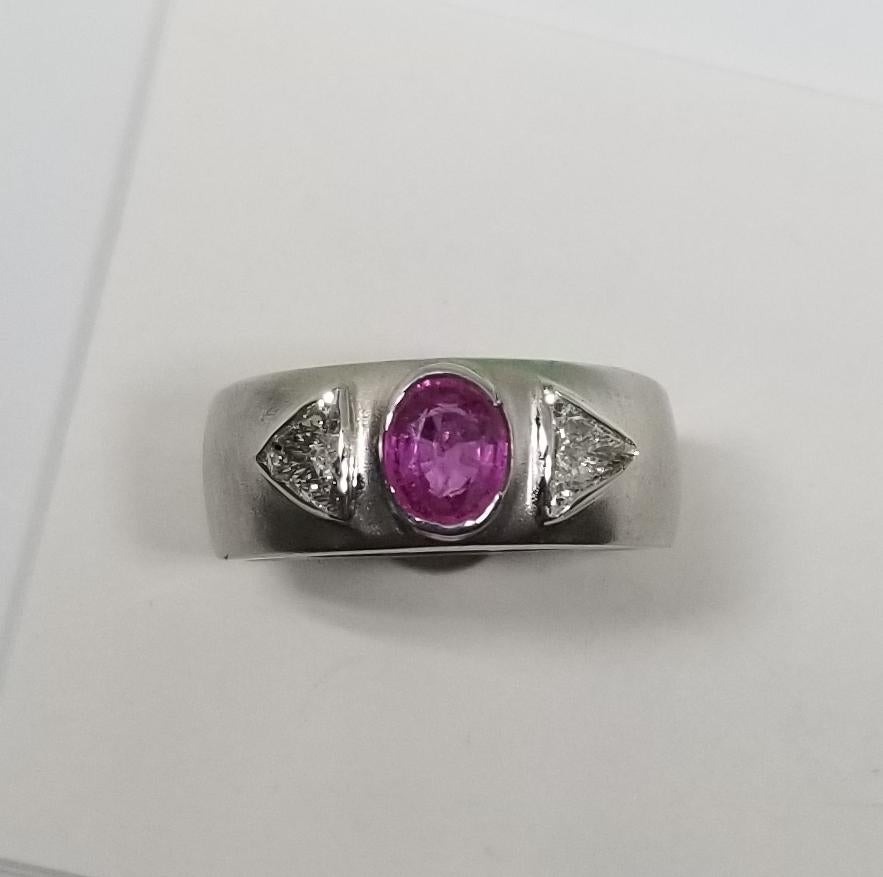 14k white gold pink sapphire and diamond ring, containing 1 oval cut pink sapphire of gem quality weighing .80pts. and 2 trillion cut diamonds of very nice quality weighing .43pts. bezel set on a 