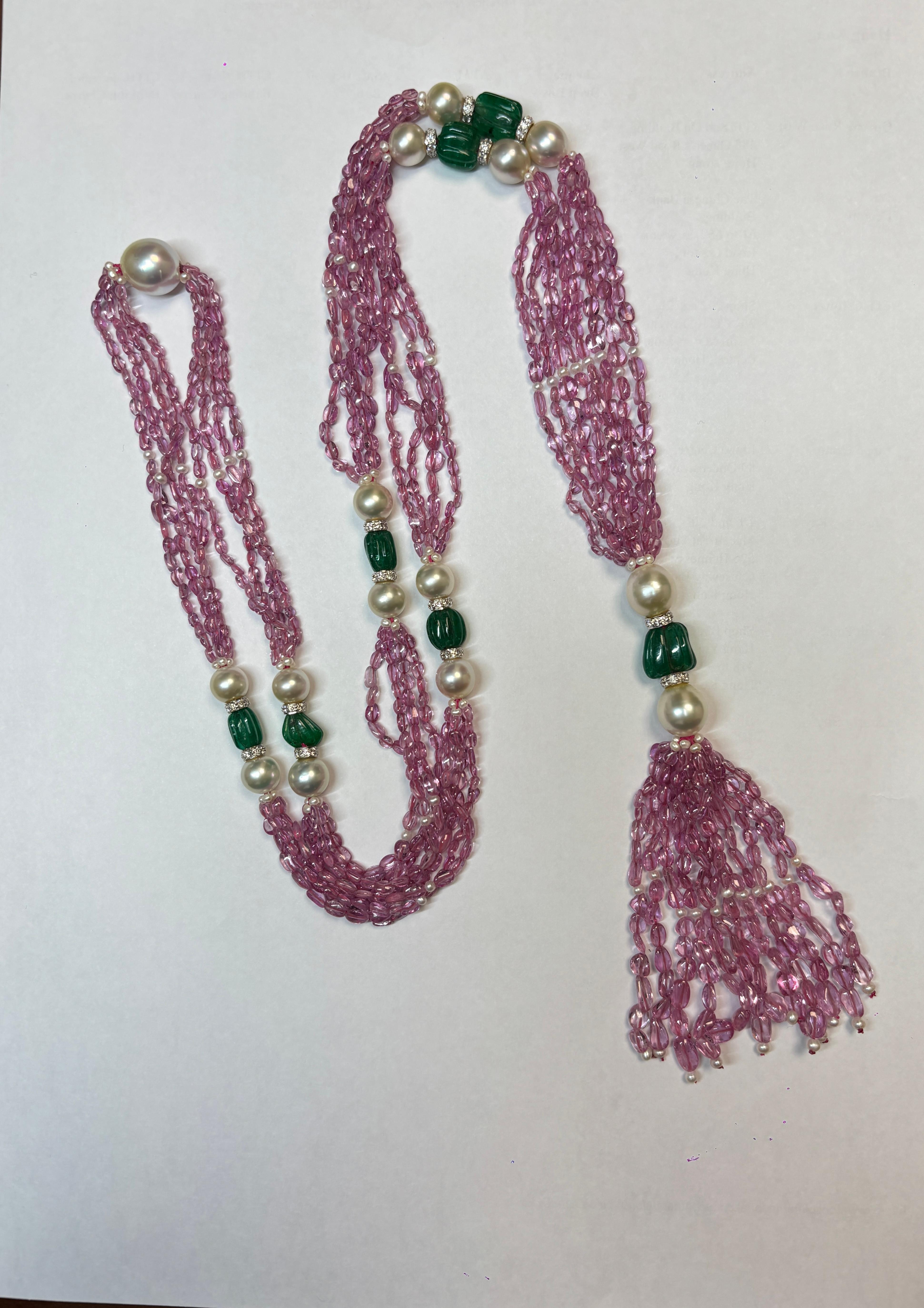 Diese atemberaubende 37-Zoll-Halskette besteht aus 306 Karat leuchtenden rosa Saphiren und kunstvoll geschnitzten sambischen Smaragden. 

Rosa Saphire, die Leidenschaft und Liebe symbolisieren, werden durch Smaragde, die für Erneuerung und Wachstum