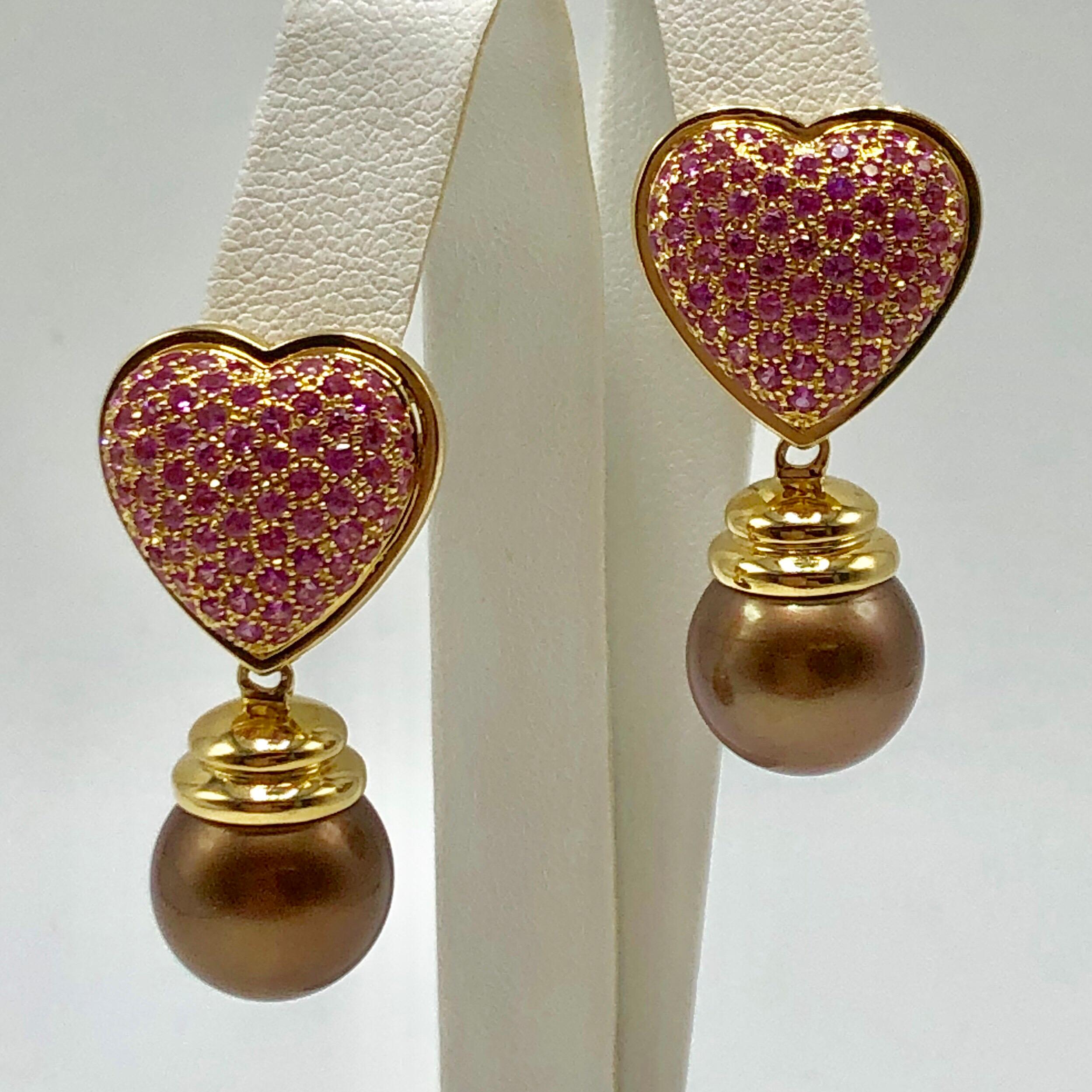 Chocolate Tahitian pearls and pink sapphire hearts... Yes, please!

3.68 CTS of pink sapphires encrust 18K yellow gold hearts. 13.5mm milk chocolate colored Tahitian brown pearls dangle from each heart. 

Stamped: 750, OC