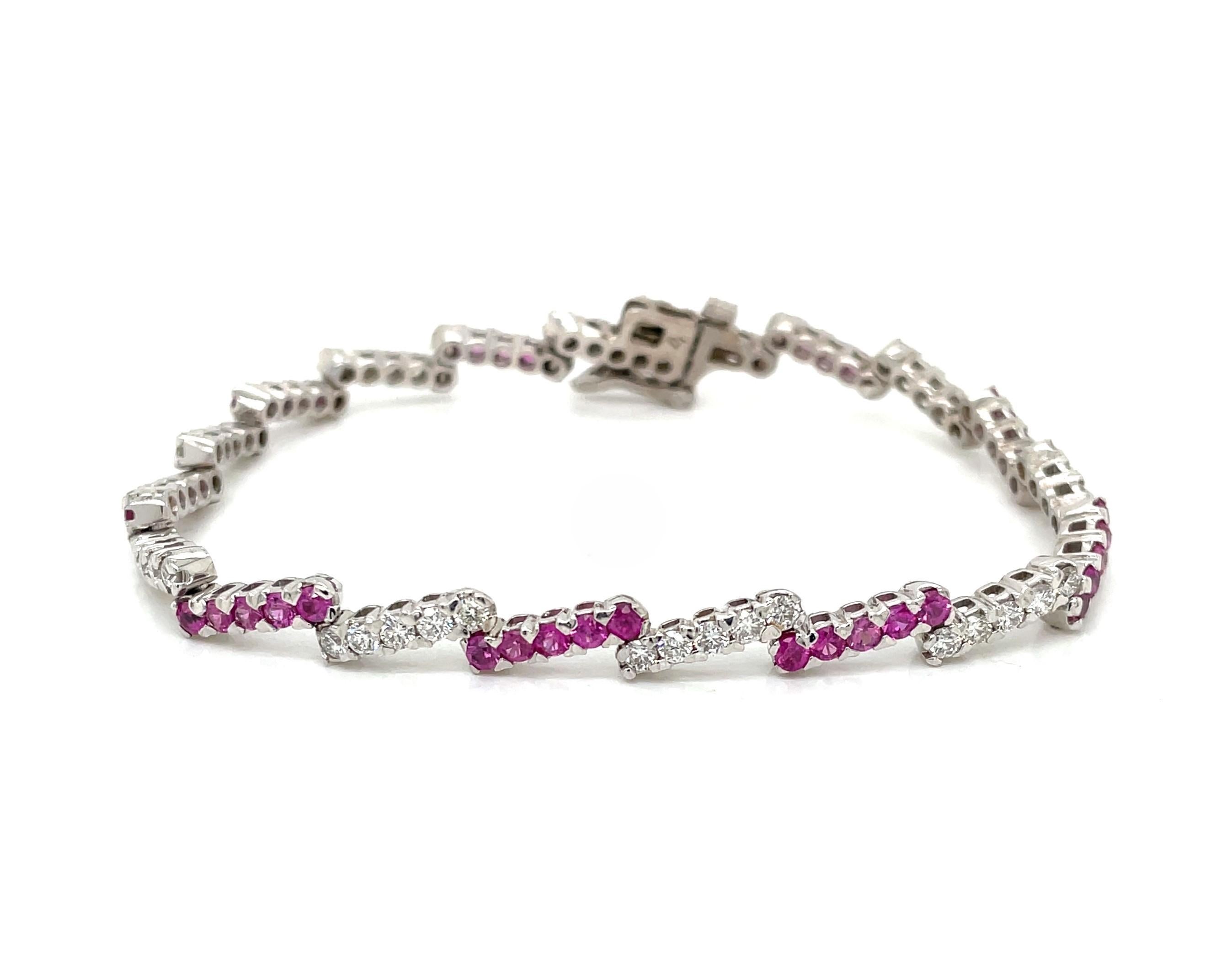 Pretty in pink with a twist on a classic style. Cheerful pink sapphires and sparkling white diamonds are set in 14 karat white gold to create this youthful tennis bracelet. Creatively arranged in a zig zag pattern, this colorful bracelet has 1.35