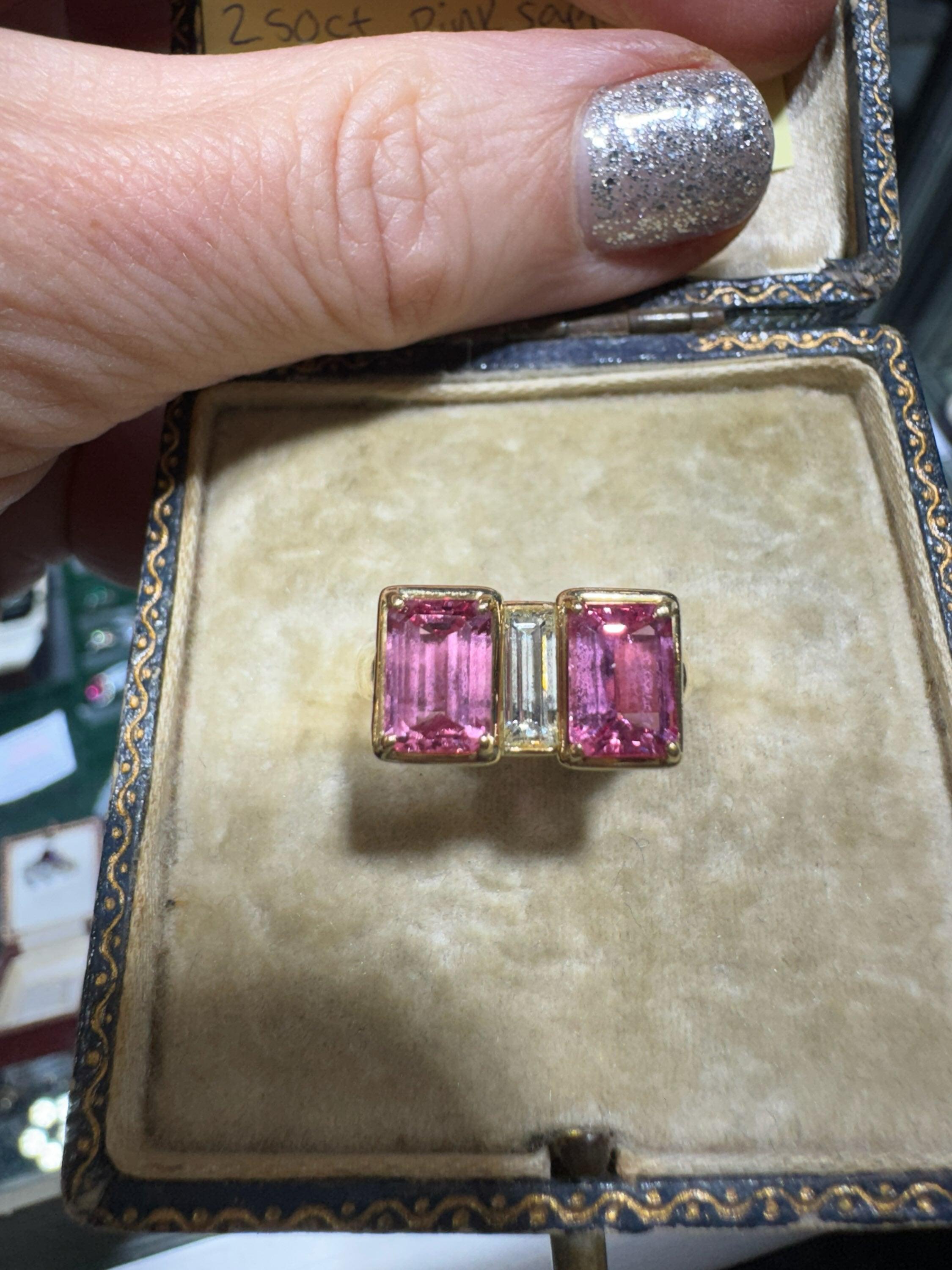 Estate Ring, 2 rosa Saphire im Smaragdschliff 2,50 ct 1 Diamant im Baguetteschliff 0,35 ct H-I VS2, 18K Gelbgold 8,60g. Größe 7

Schmuck Typ : Ring
Metall Typ : 18K Gelbgold
Metall Gewicht: 8,60 Gramm
Ring Größe : 7
Marke : Estate
Zeitraum: 1990er