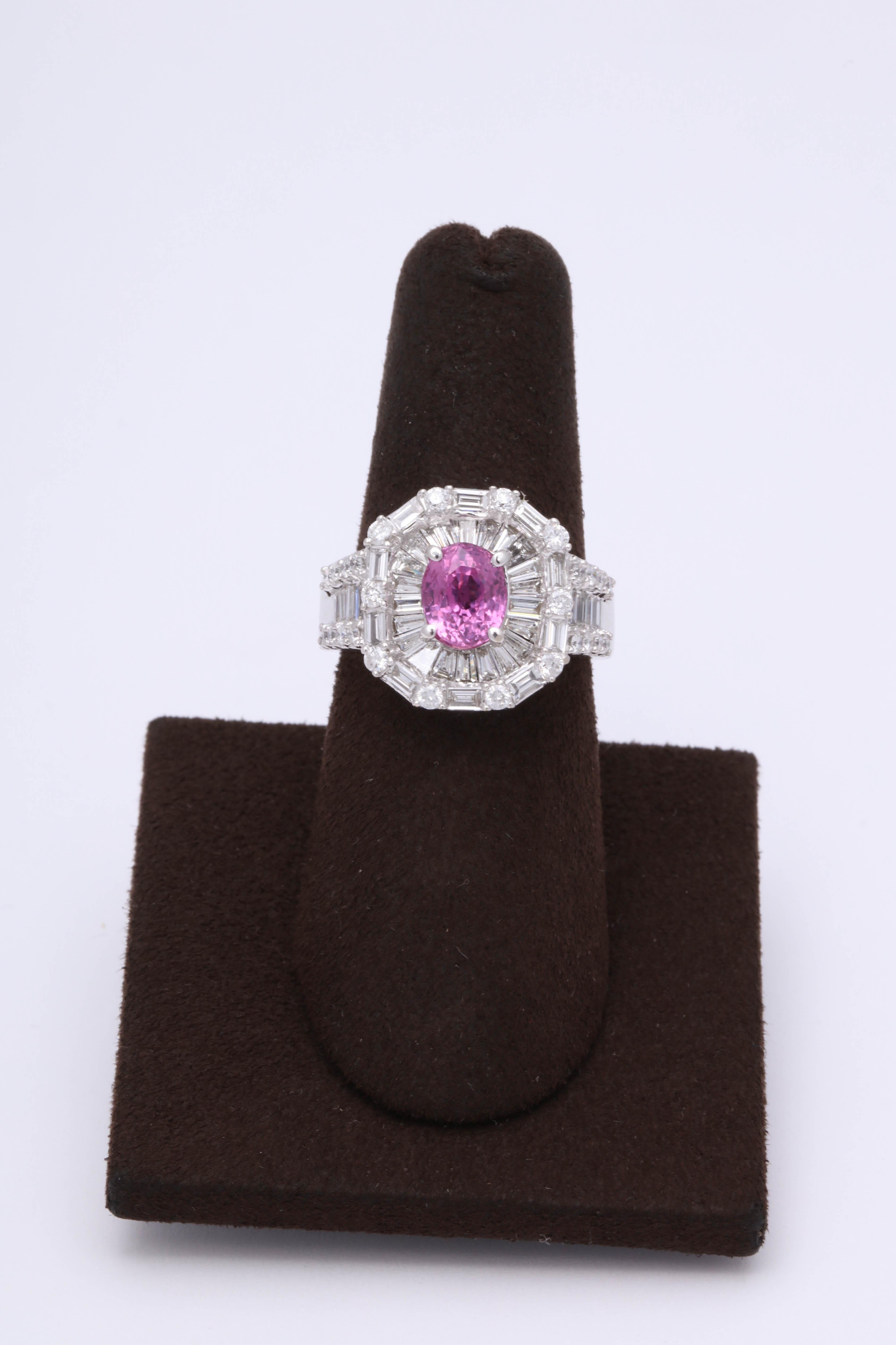 

A vibrant and vivid pink sapphire center stone surrounded by baguette and round cut diamonds.

1.82 carat center Pink Sapphire Oval. 

1.66 carats of F VS round and baguette cut diamonds.

18k white gold 

Currently a size 6.5 but can be easily