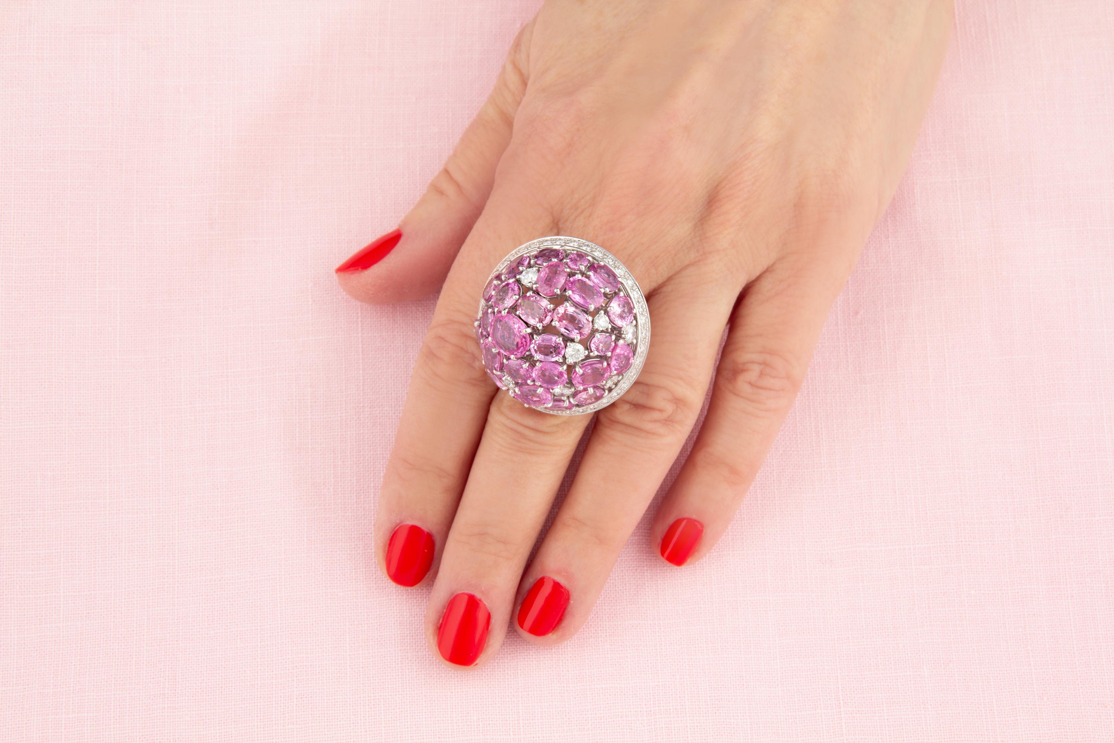 L'anello cocktail con zaffiro rosa e diamante a cupola presenta 22,96 carati di zaffiri di Ceylon sfaccettati di colore brillante e dal taglio ovale. Gli zaffiri sono accuratamente intervallati e circondati da una corona di diamanti rotondi per un