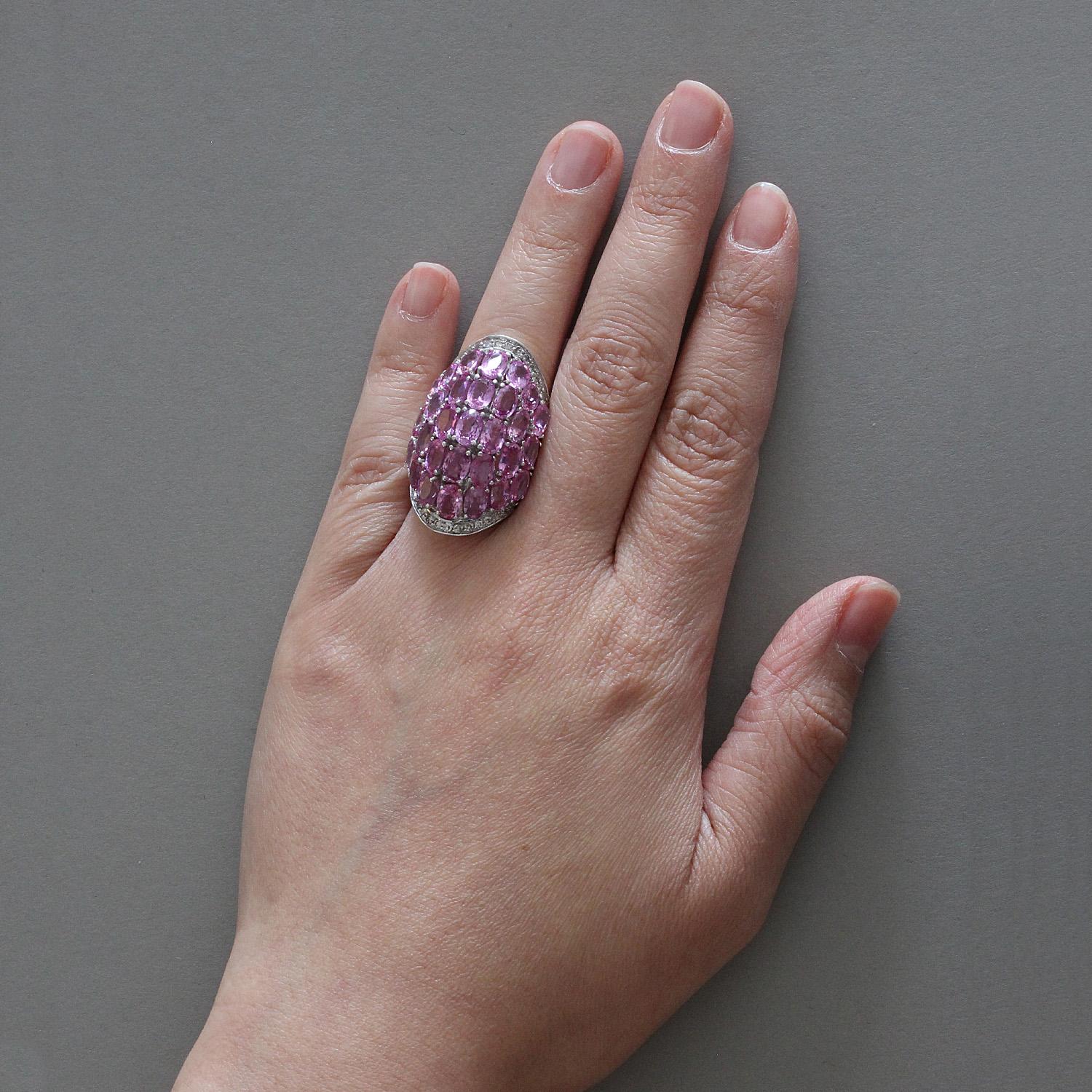 A cocktail ring featuring 30 oval cut pink sapphires weighing 16.22 carats. They are complemented by 1.00 carat of diamonds set in white gold. 

Size 5 ½ 
