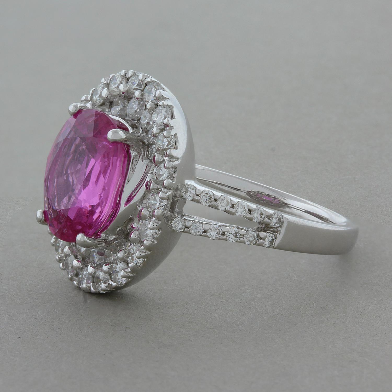 This ring features an oval shaped 3.25 carat bubble gum pink sapphire. The color is pure rich pink with not shades of brown, a true gem. It is accented by 0.93 carats of round brilliant cut diamonds that are set around in gemstone and on the