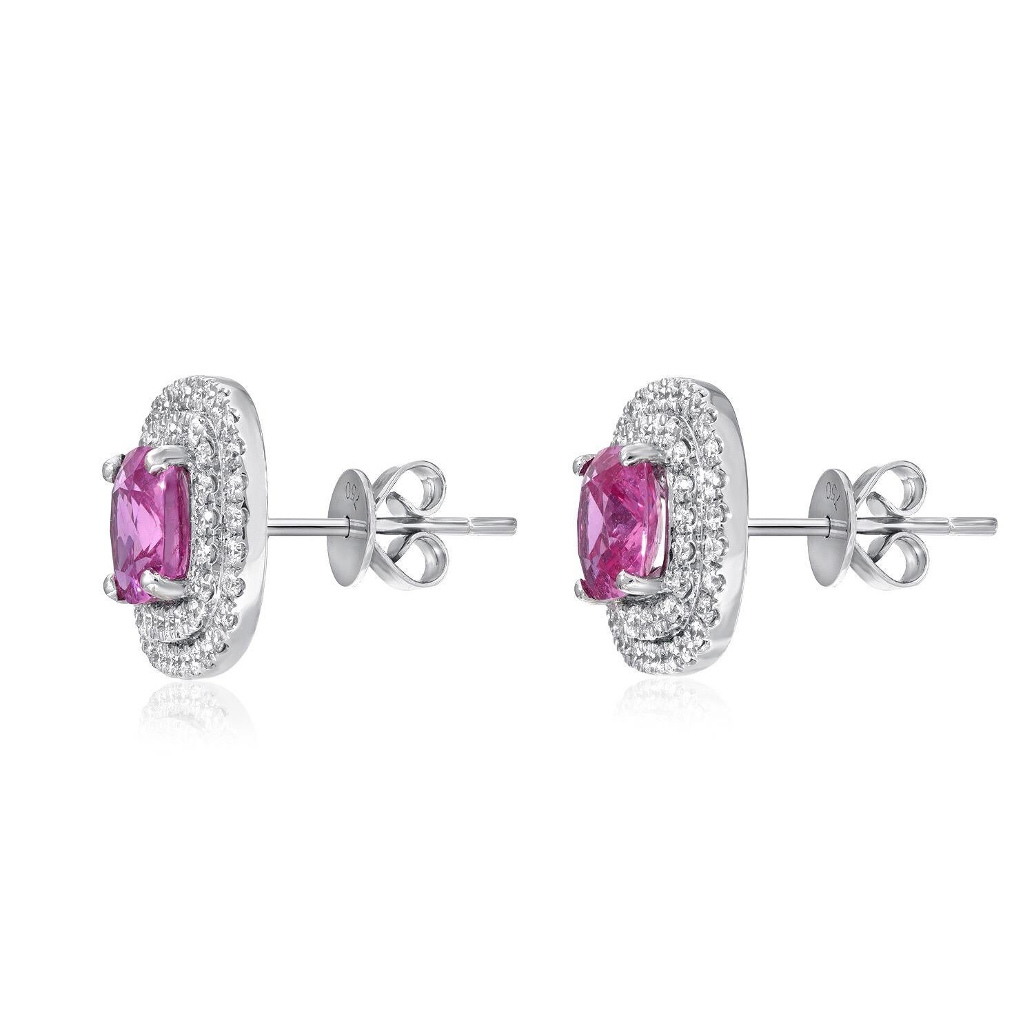 Pink Sapphire diamond stud earrings featuring a pair of cushion cut Pink Sapphire weighing a total of 3.31 carats, surrounded by a total of 0.91 carats of micro pave set diamonds, in 18K white gold.
Approximately 0.50 inches wide.
Returns are