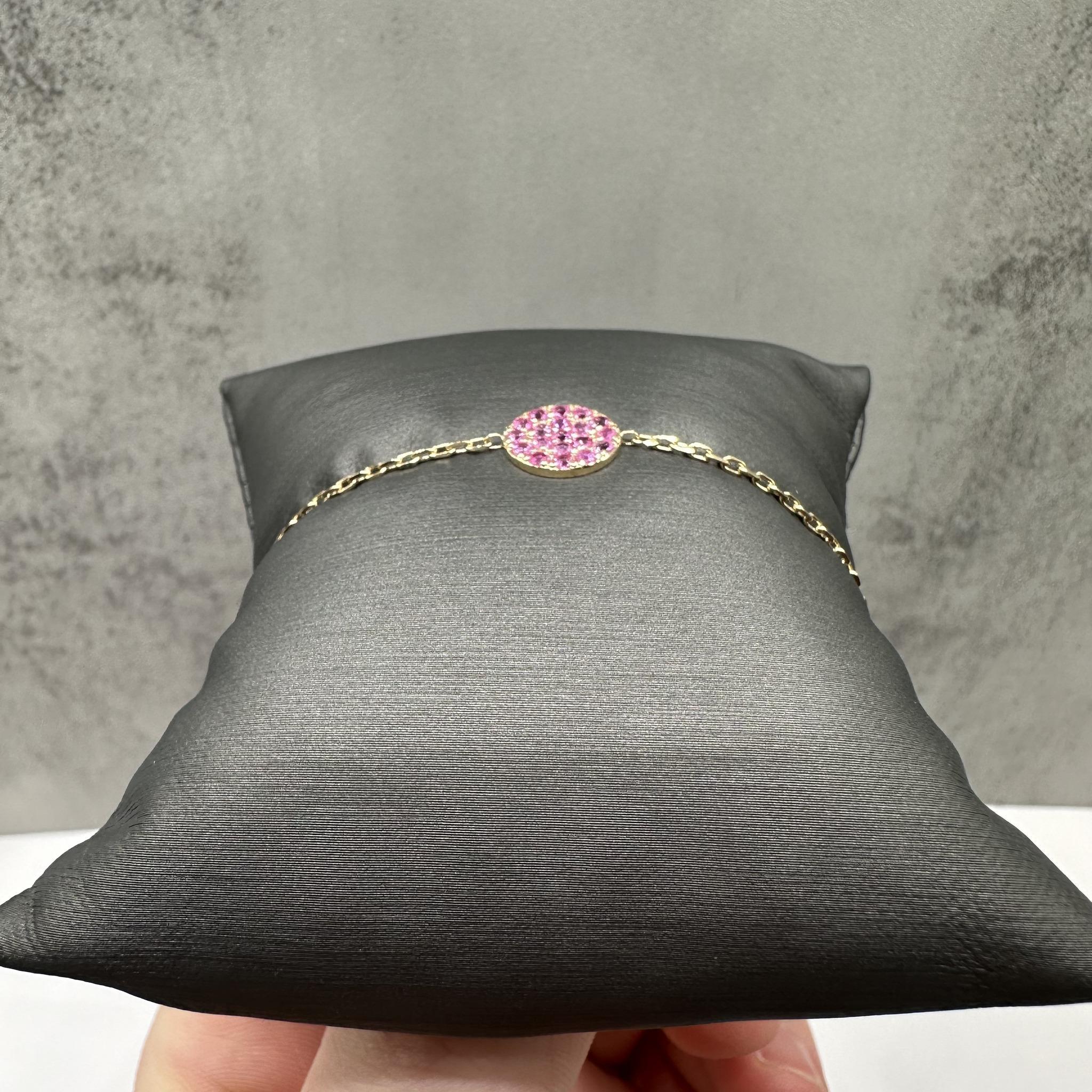 Esta elegante pulsera de disco de zafiro rosa en oro amarillo de 14 quilates presenta 0,57 quilates de peso total de zafiros rosas redondos engastados en un delicado diseño de disco. Los vibrantes zafiros rosas contrastan maravillosamente con el