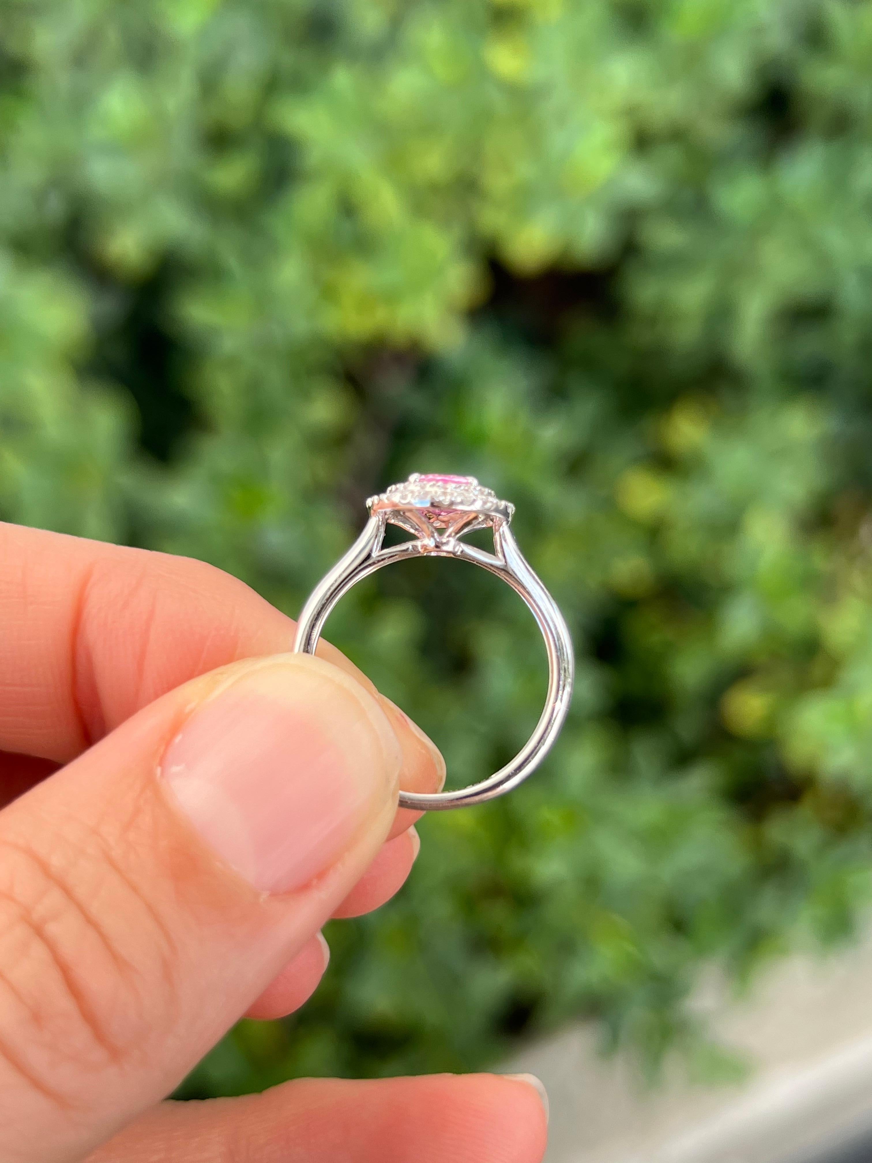 An engagement ring as unique as you love! Wow with a bright pink sapphire surrounded by a double halo of prong set diamonds. 

Features
18K white gold
.92 carat total weight pink sapphire
.28 carat total weight in diamonds
Ring size 6.5, can be sized