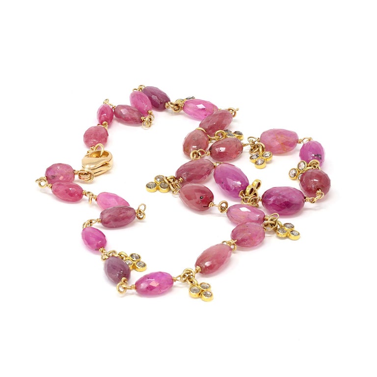 Handmade 18 karat rose gold, pink sapphire faceted bead and diamond necklace, composed of a graduated strand of pink sapphire beads weighing approximately 85 carats, spaced by small floret pendants set with diamonds weighing 0.75 carat. The gross