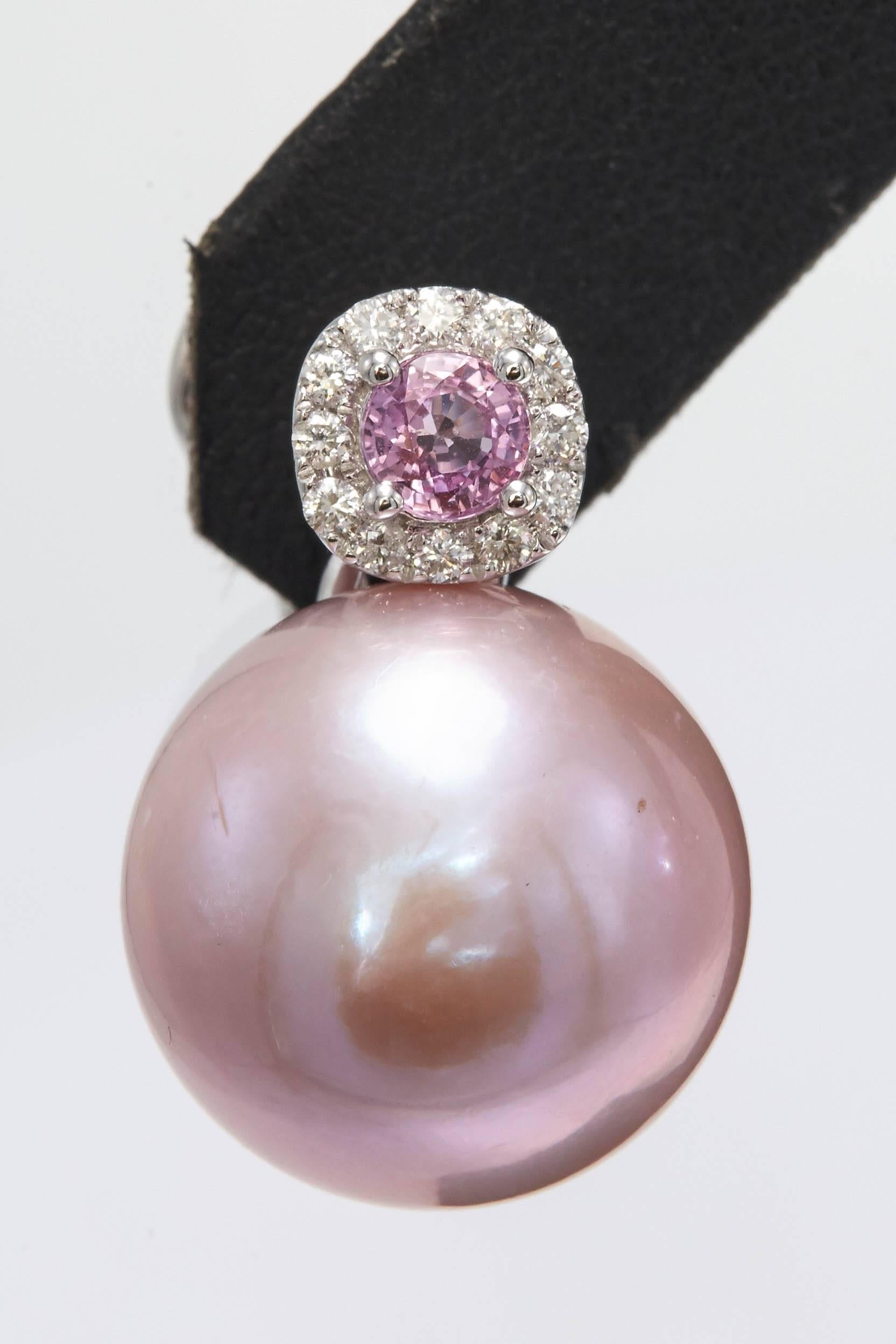 Pendientes colgantes de oro blanco de 18 quilates con dos zafiros rosas de 0,56 quilates, flanqueados por 24 brillantes redondos de 0,24 quilates y dos perlas rosas de agua dulce de 14-15 mm.

Disponible en diferentes colores de perlas, oro y