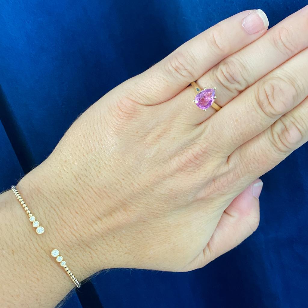 This gorgeous modern hidden halo engagement ring was custom made just for this vibrant pink sapphire. Show your partner that you two make a perfect 