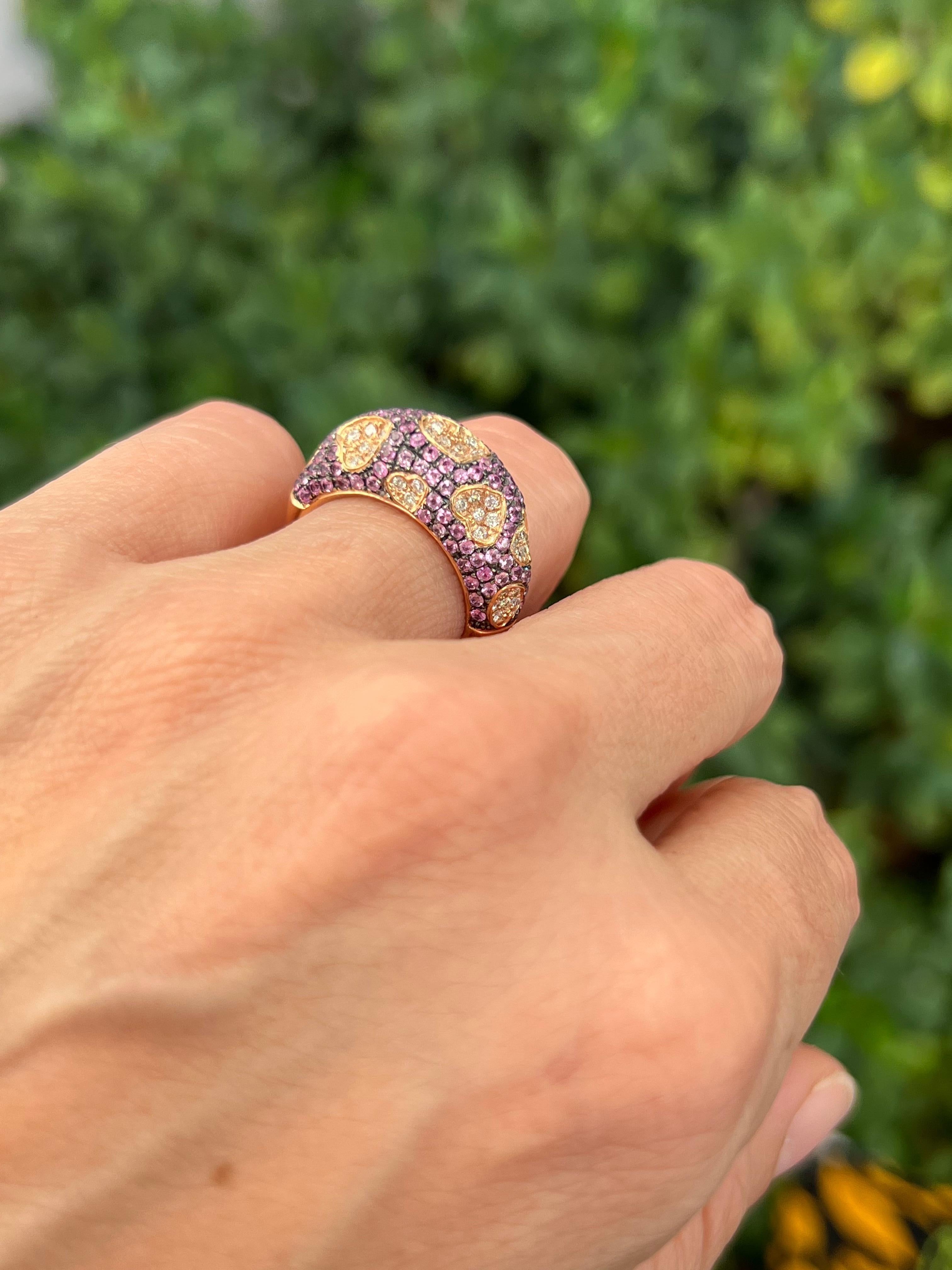 Floating pave diamond hearts adorn this whimsical ring against a pink sapphire background. Finished on the inside with a playful hearts gallery. 

Features
18K rose gold
1.31 carat total weight in pink sapphire
.38 carat total weight in