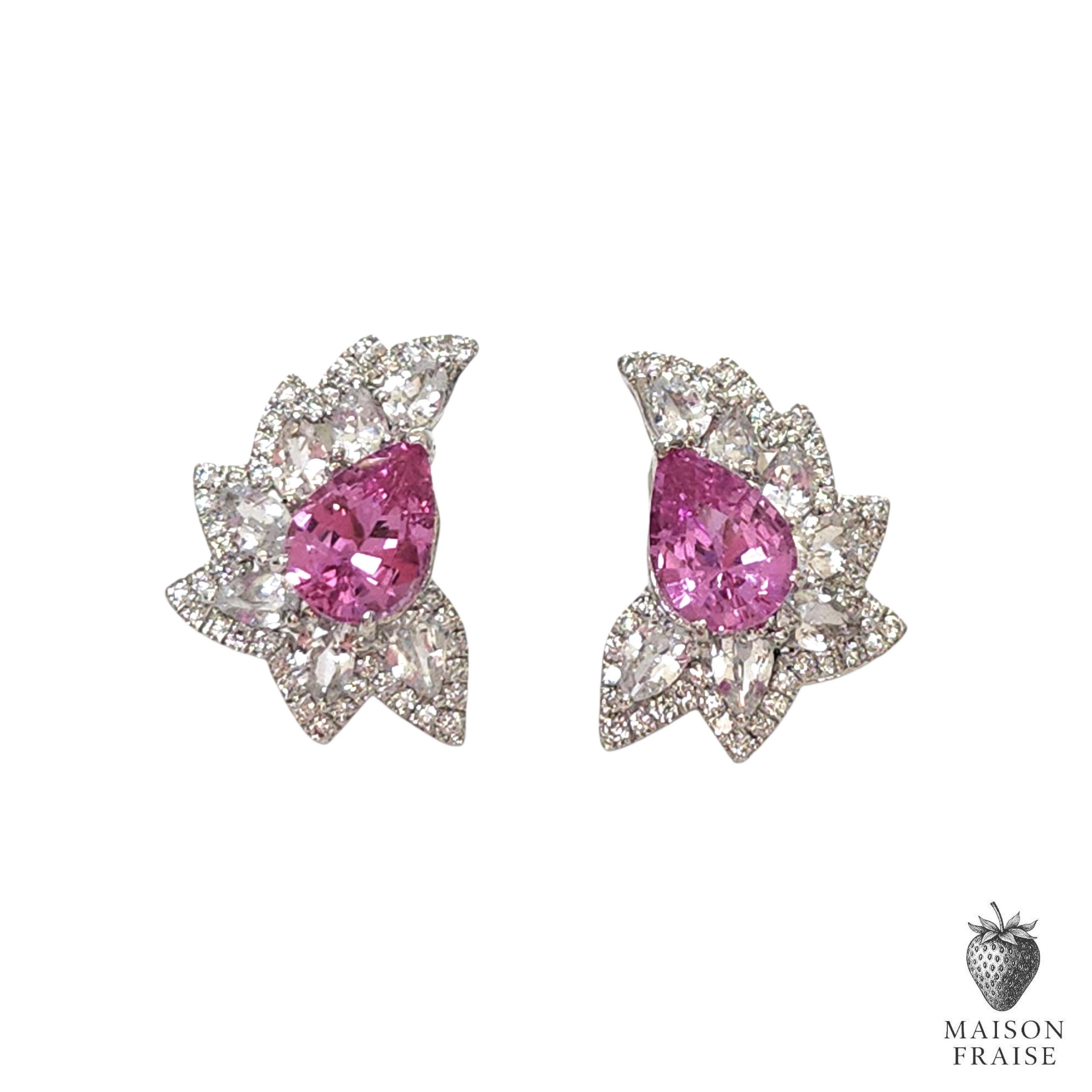 A luminous duet of color and light, these elegant earrings are centered around a pair of striking natural pink sapphires, weighing a combined total of approximately 1.36 carats (0.68ct per stone). Certified by The Natural Sapphire Company, the