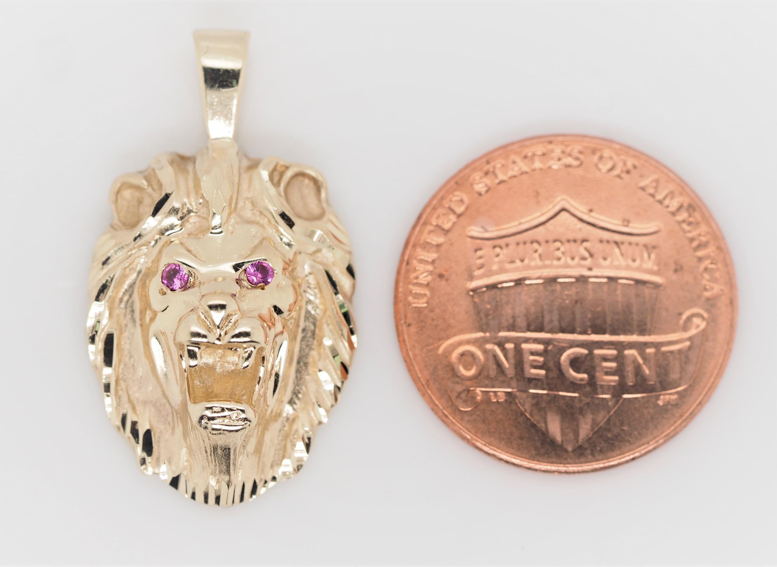 Crafted of solid 14K yellow gold, this beautiful lion charm with two pink sapphires is truly one of a kind. The charm features beautiful engravings and details all over it, making this lion come to life. It's the perfect piece to add to your