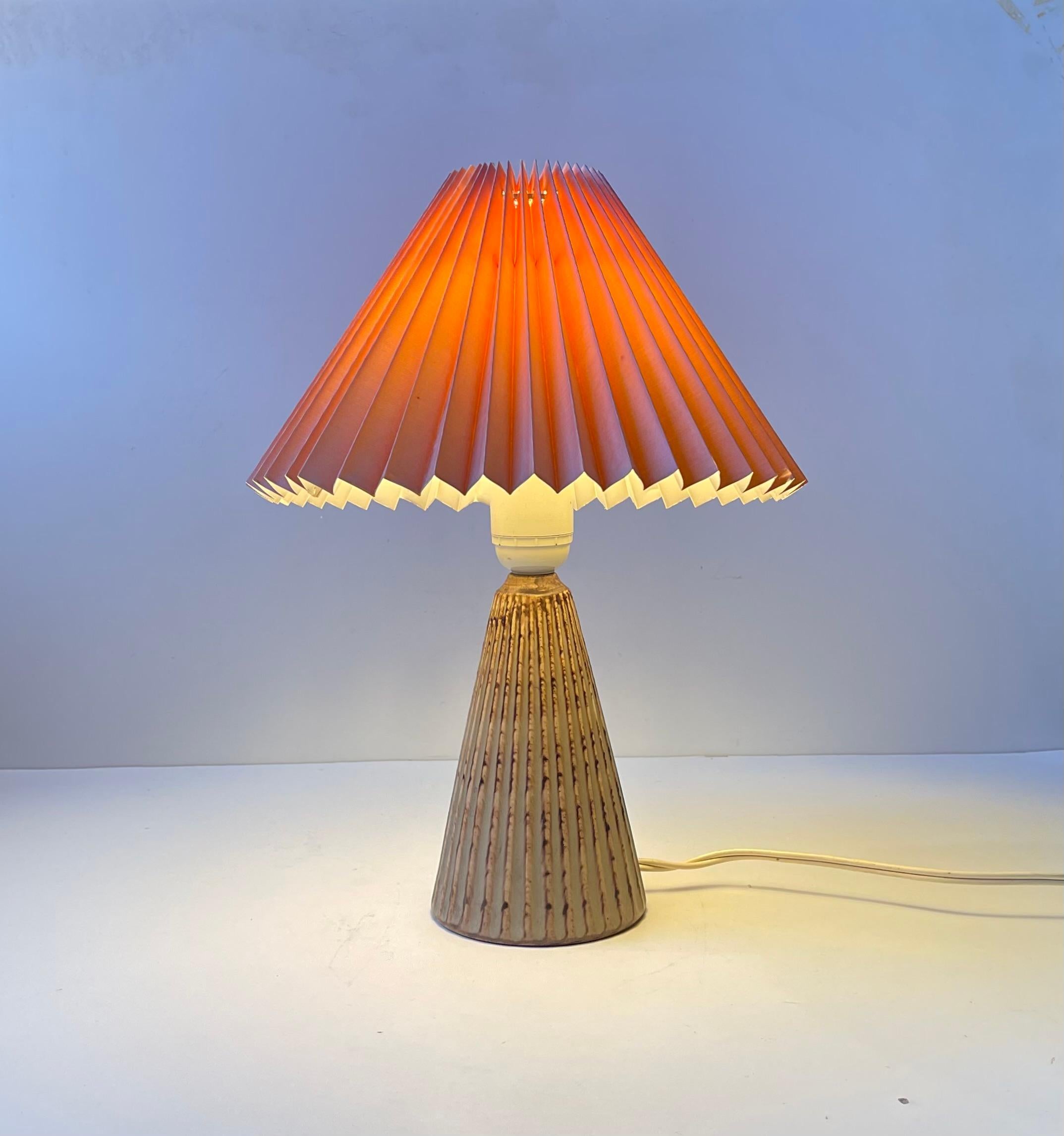 One of the most sought after designs by the danish ceramist Einar Johansen. This conical version with its earthy and olive green glazes in combination with the fully fluted ceramic body is simply to die for. It comes mounted with a pink fluted