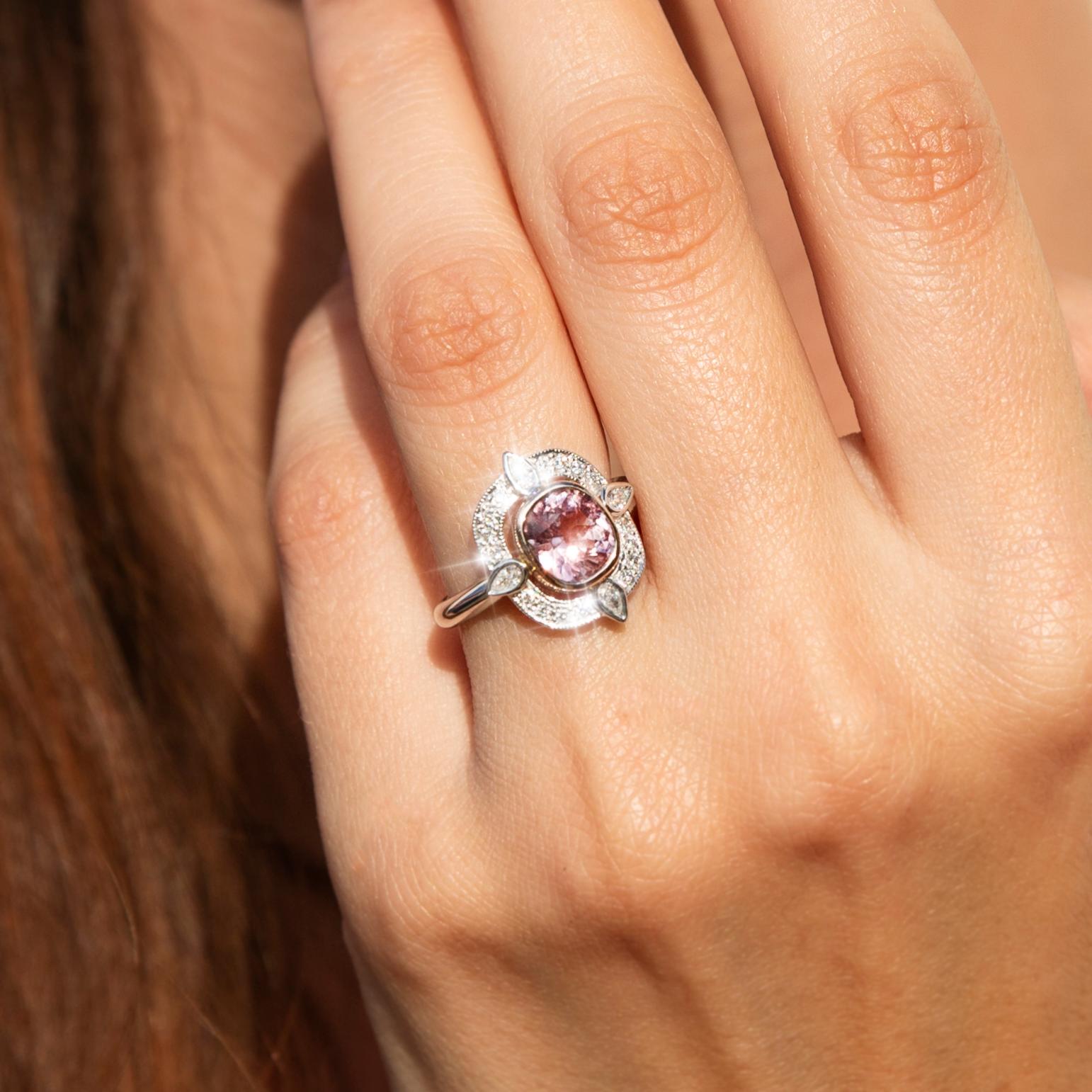 Lovingly handcrafted in shimmering 18 carat white and rose gold, this wonderful contemporary cluster ring is a masterwork of elegant design. The gleaming tapered white gold band holds a gorgeous gallery with an adorable cushion cut pink spinel