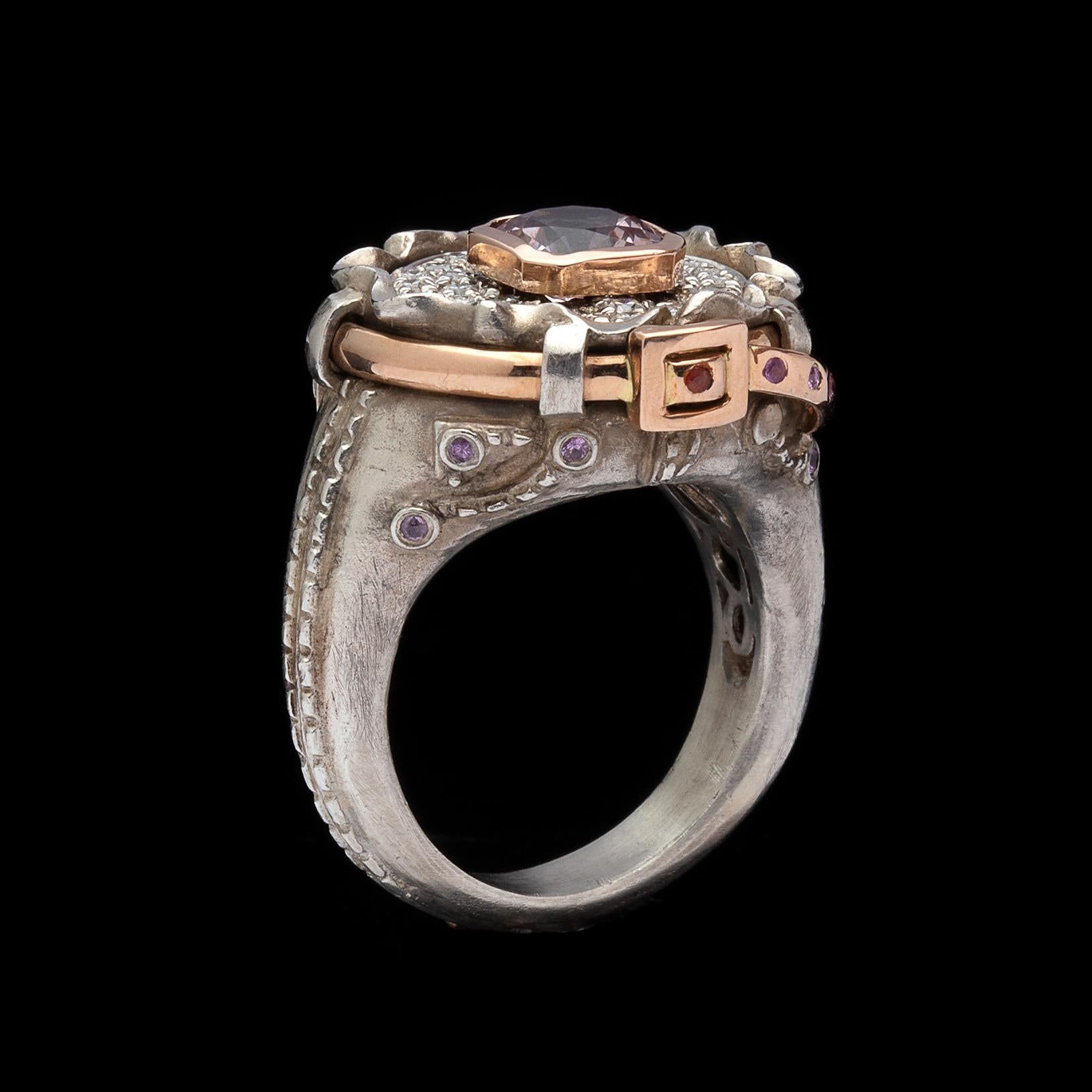 Fun and elegant, the silver and 18k rose gold ring centers a 1.54-cts. bezel-set radiant-cut pale pink spinel, surrounded by 37 pave-set round brilliant-cut diamonds, atop a silver mounting designed as a pair of blue jeans, complete with gold belt